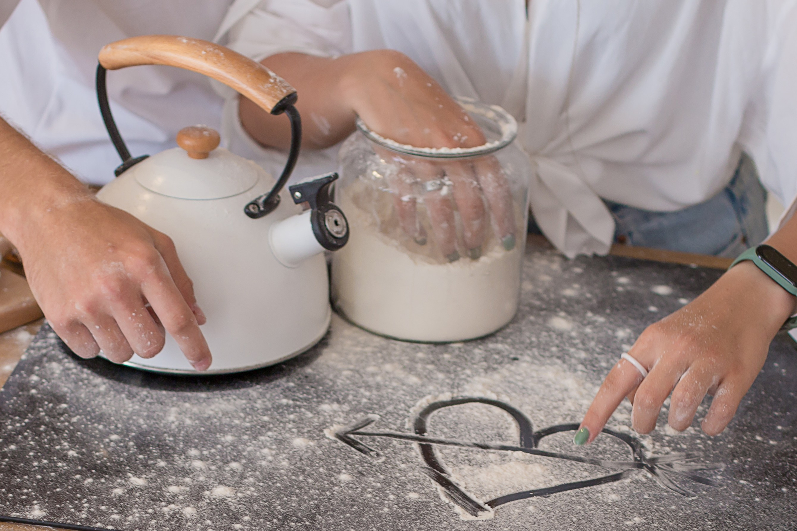 рисунок сердца на плите на фоне рассыпанной муки