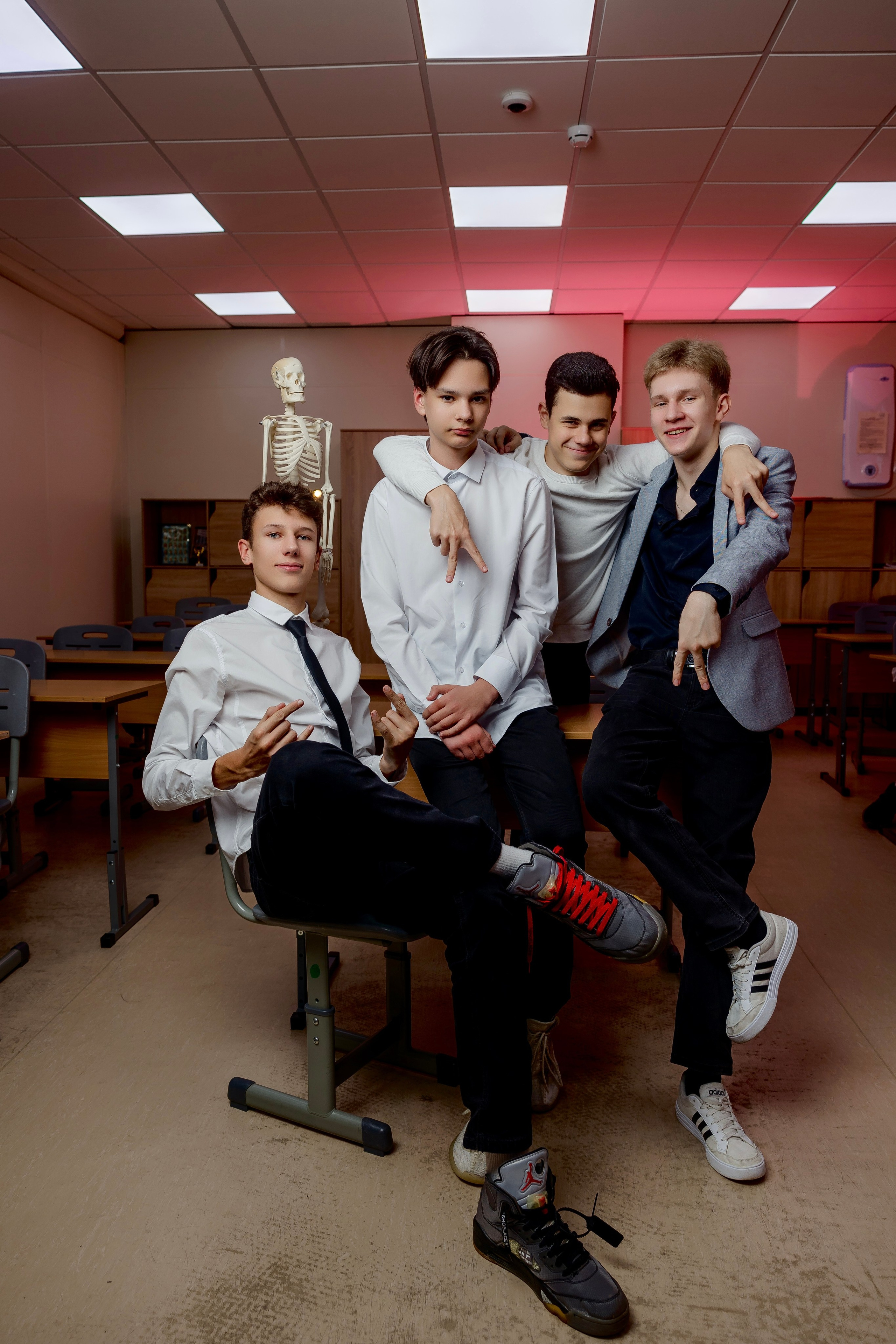 Молодые люди фотографируются в школе на стуле со скелетом