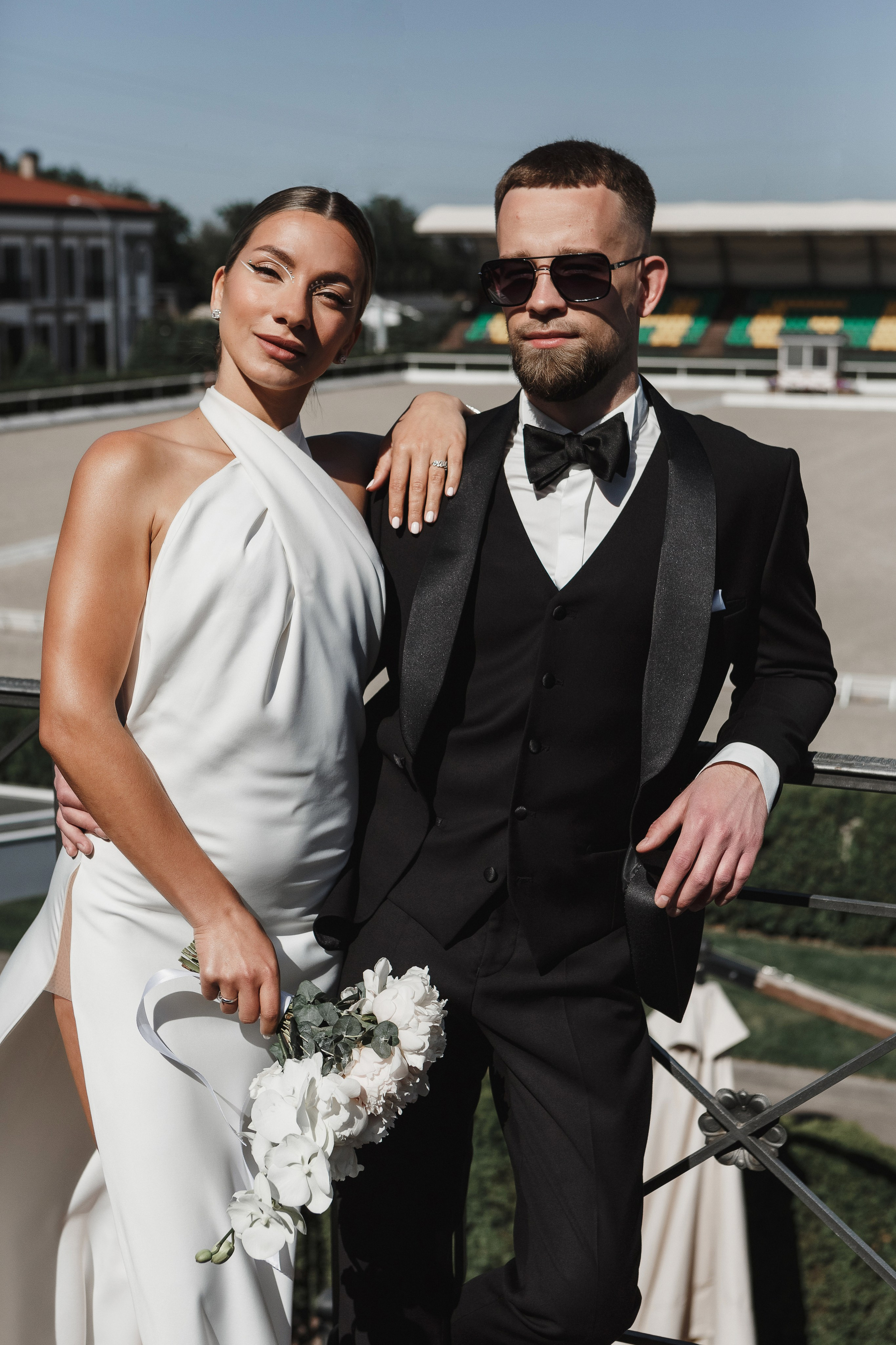 Свадебная пара на фоне ипподрома Golden Horse в Таганроге, стильный образ жениха и невесты, фотограф Антон Бакарюк