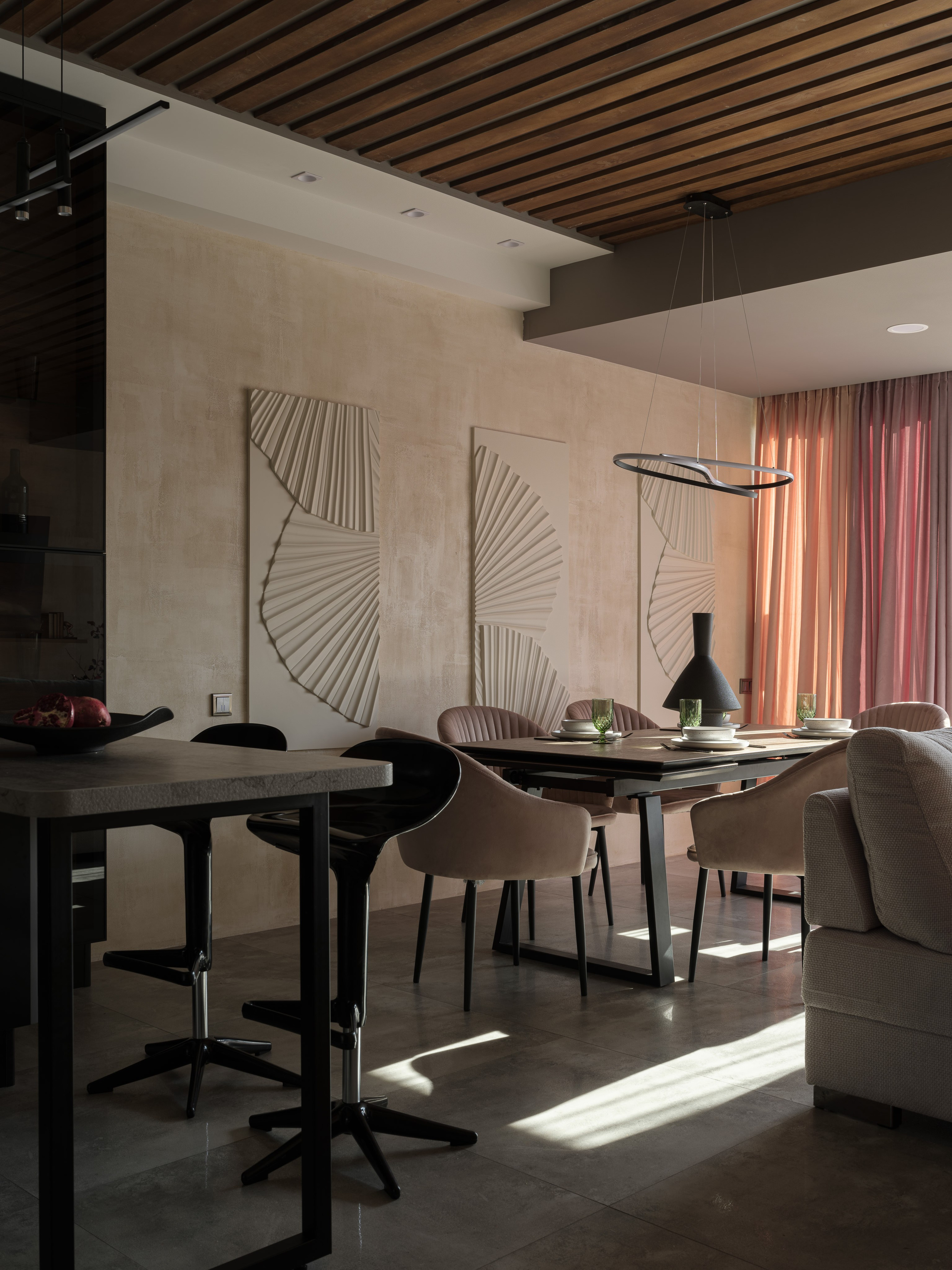 Современная столовая с настенными декоративными панелями, барными стульями и дизайнерским светильником. Пространство, созданное Алиной Дёровой, стилизованное Натальей Якушевой и снятое Сергеем Денисенко, наполнено уютом и балансом форм.