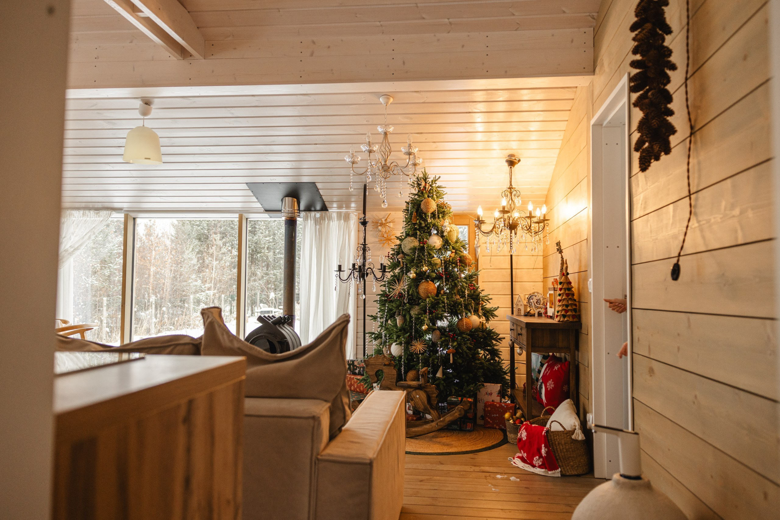 Интерьер загородного дома 'Панорама': просторная гостиная с большой зелёной ёлкой, сверкающие гирлянды и семейные фотографии
