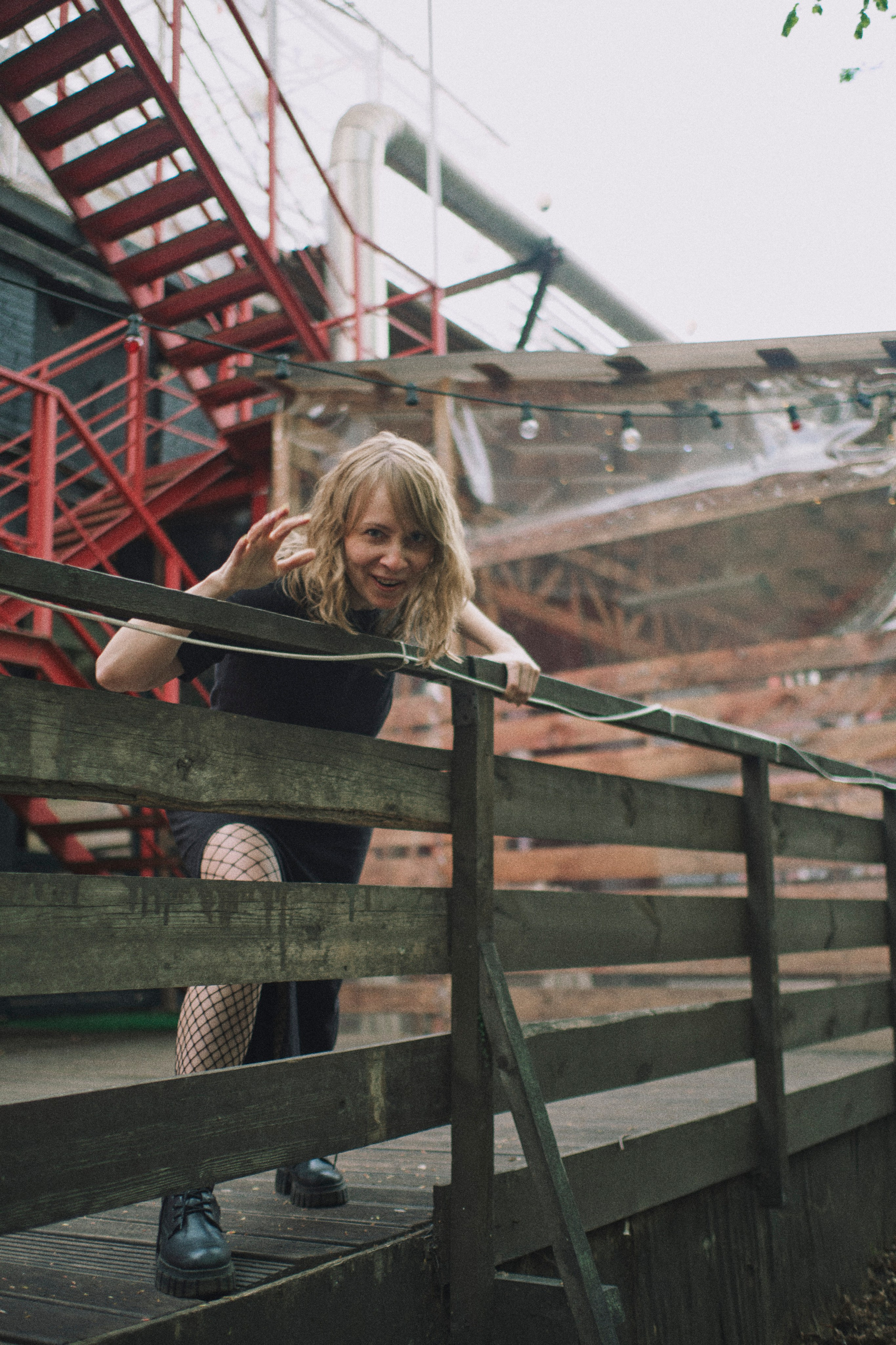 Девушка перегибается через забор, защищая свое простраство