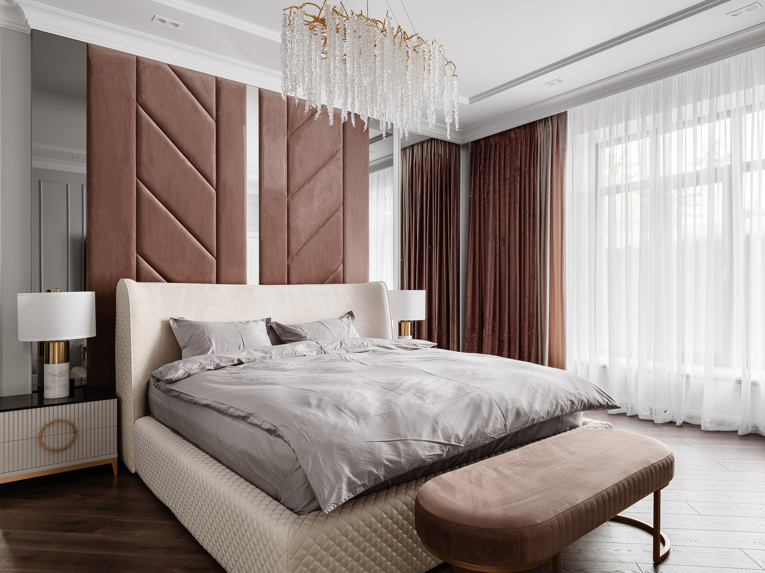 Просторная спальня с мягкой кроватью в светлой обивке, бархатным изголовьем, изысканной люстрой и большими окнами с занавесками, современный дизайн Евгении Ермошиной, фотограф Сергей Денисенко.