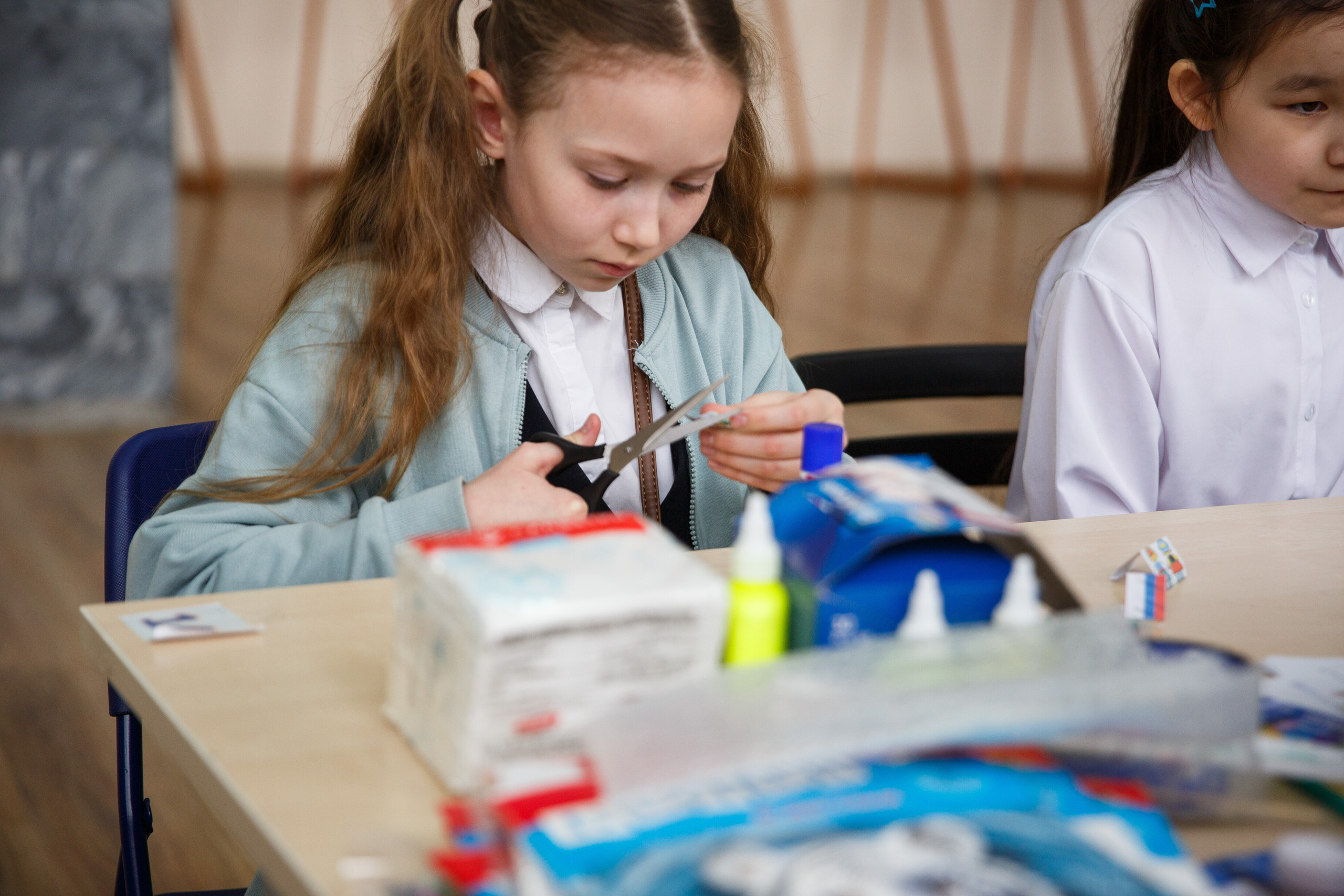 Девочка делает поделку на уроке творчества.