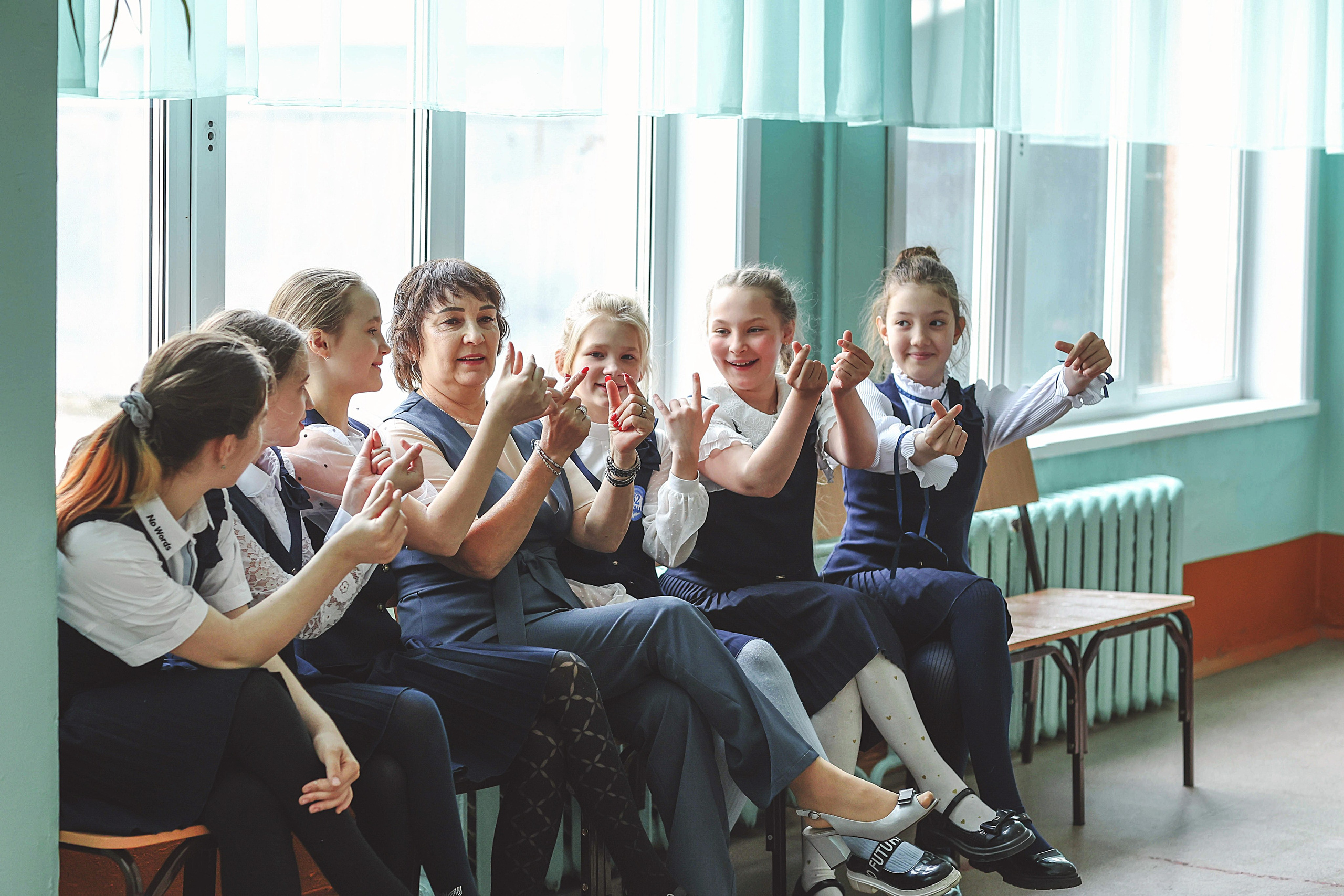 Дети в школе с учителем играют.