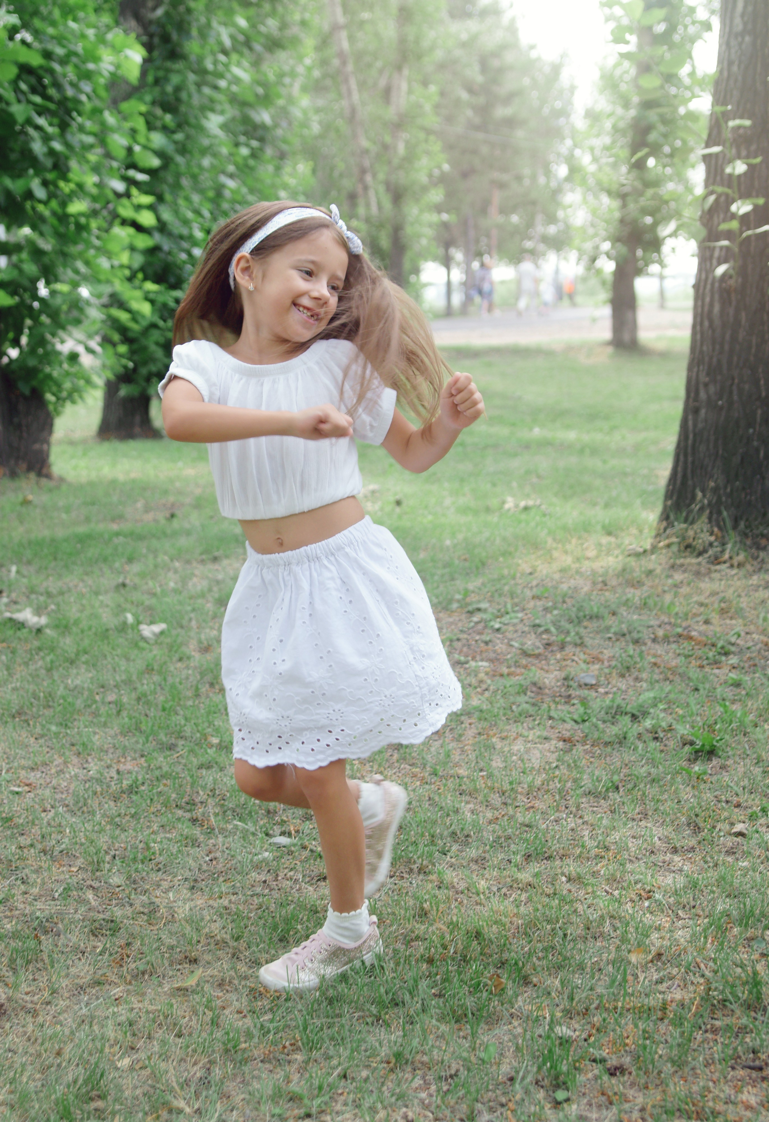Детская фотосессия летом - девочка стоя кружится в танце