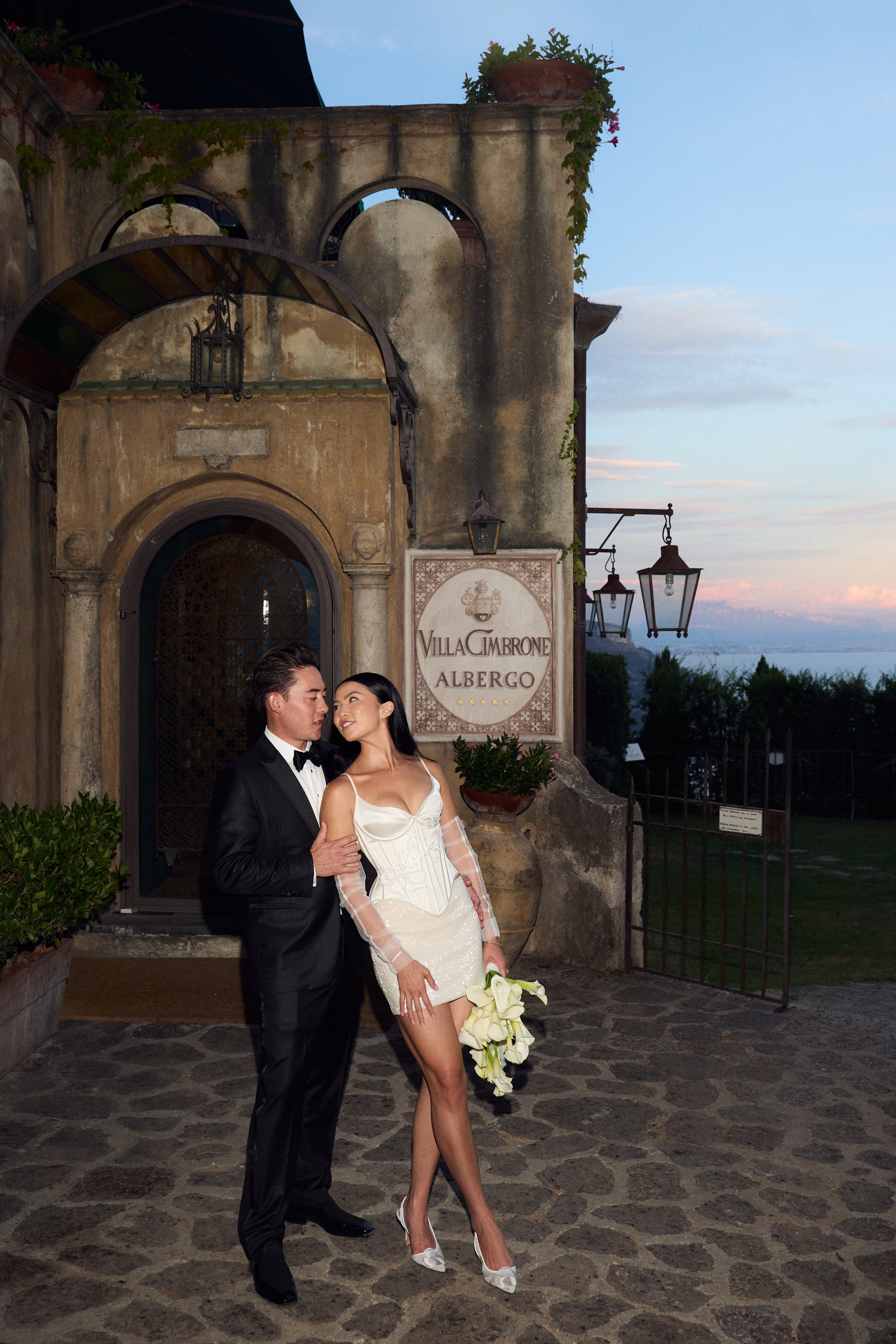Bride and groom outside the entrance to Villa Cimbrone at dusk 