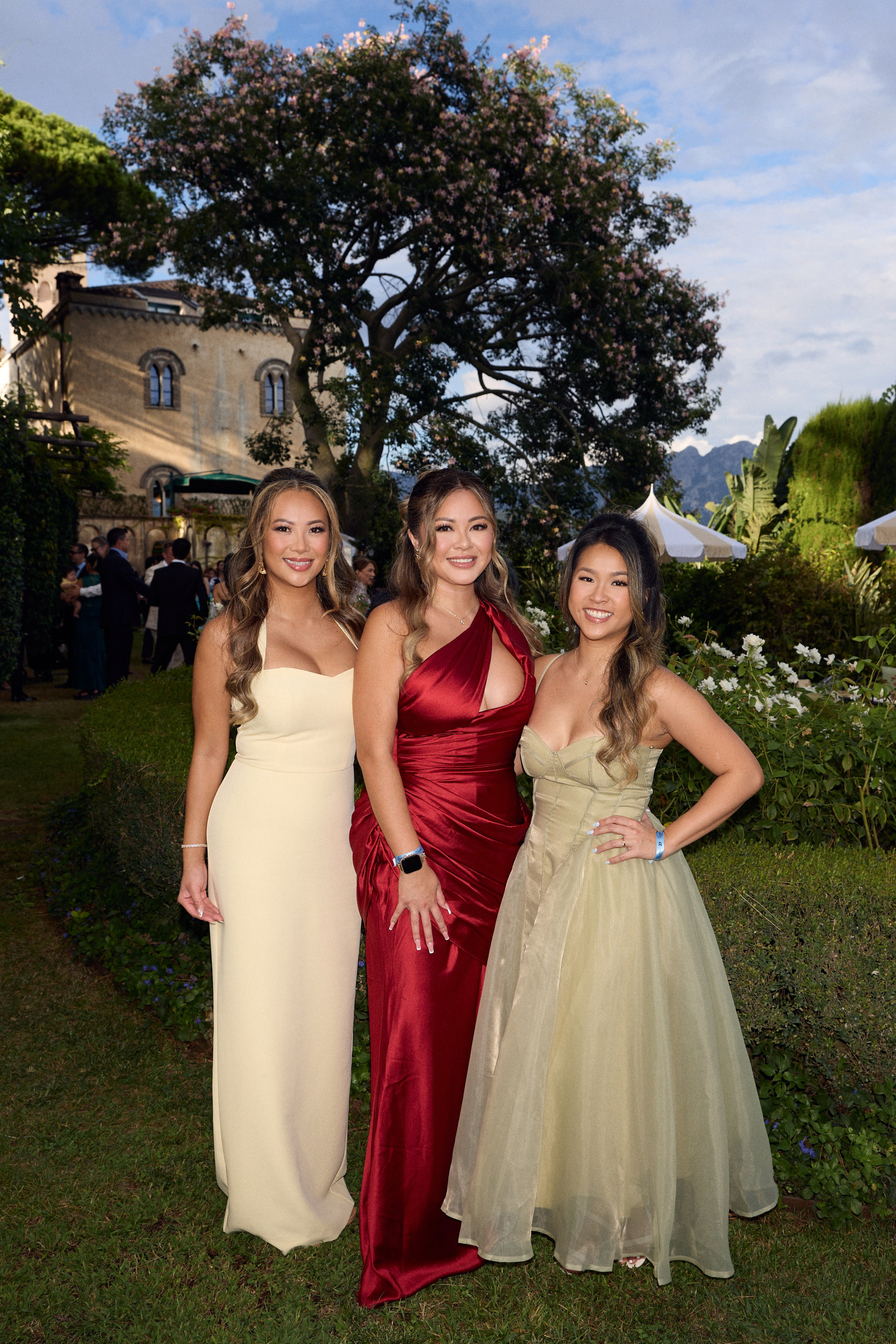 Three wedding guests posing together in the villa gardens