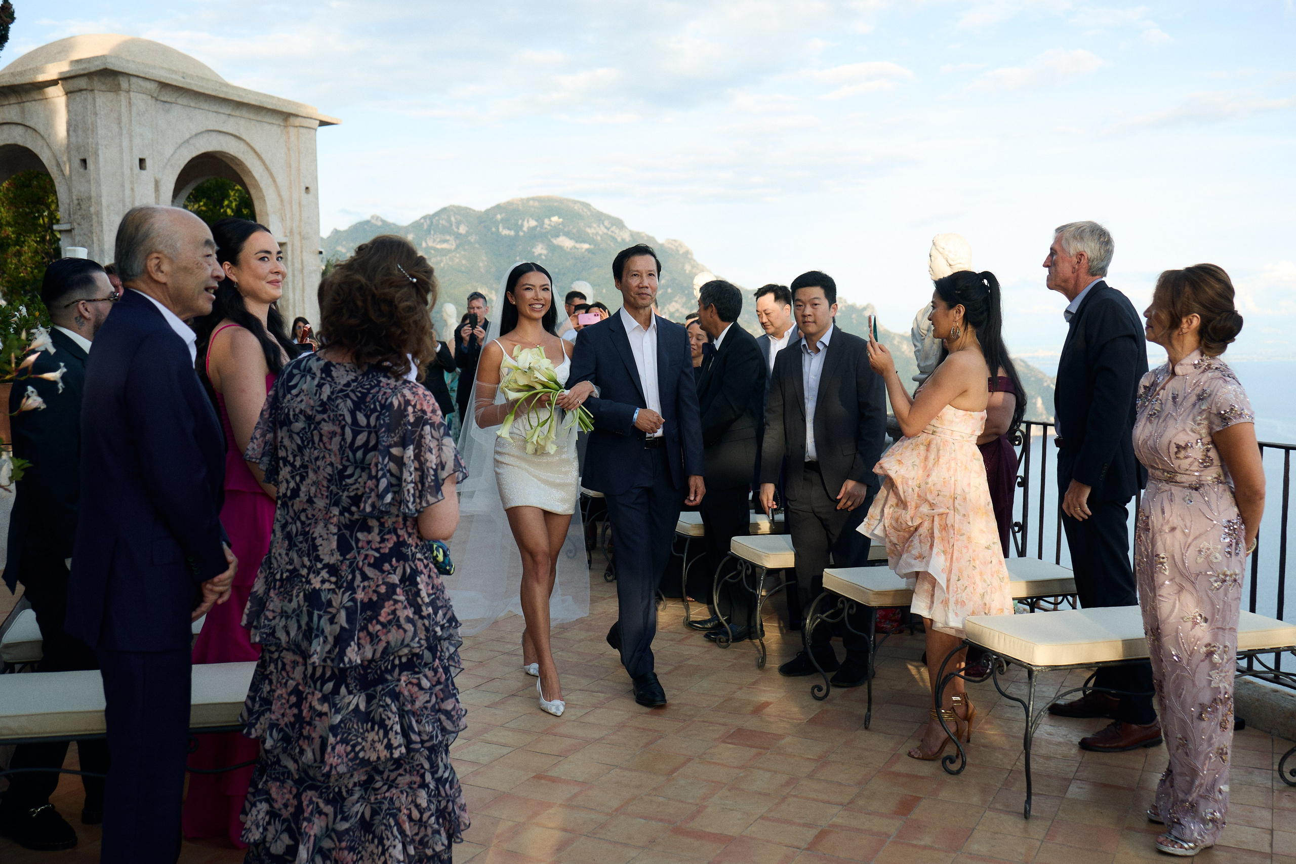 Guests standing as the bride walks down the aisle