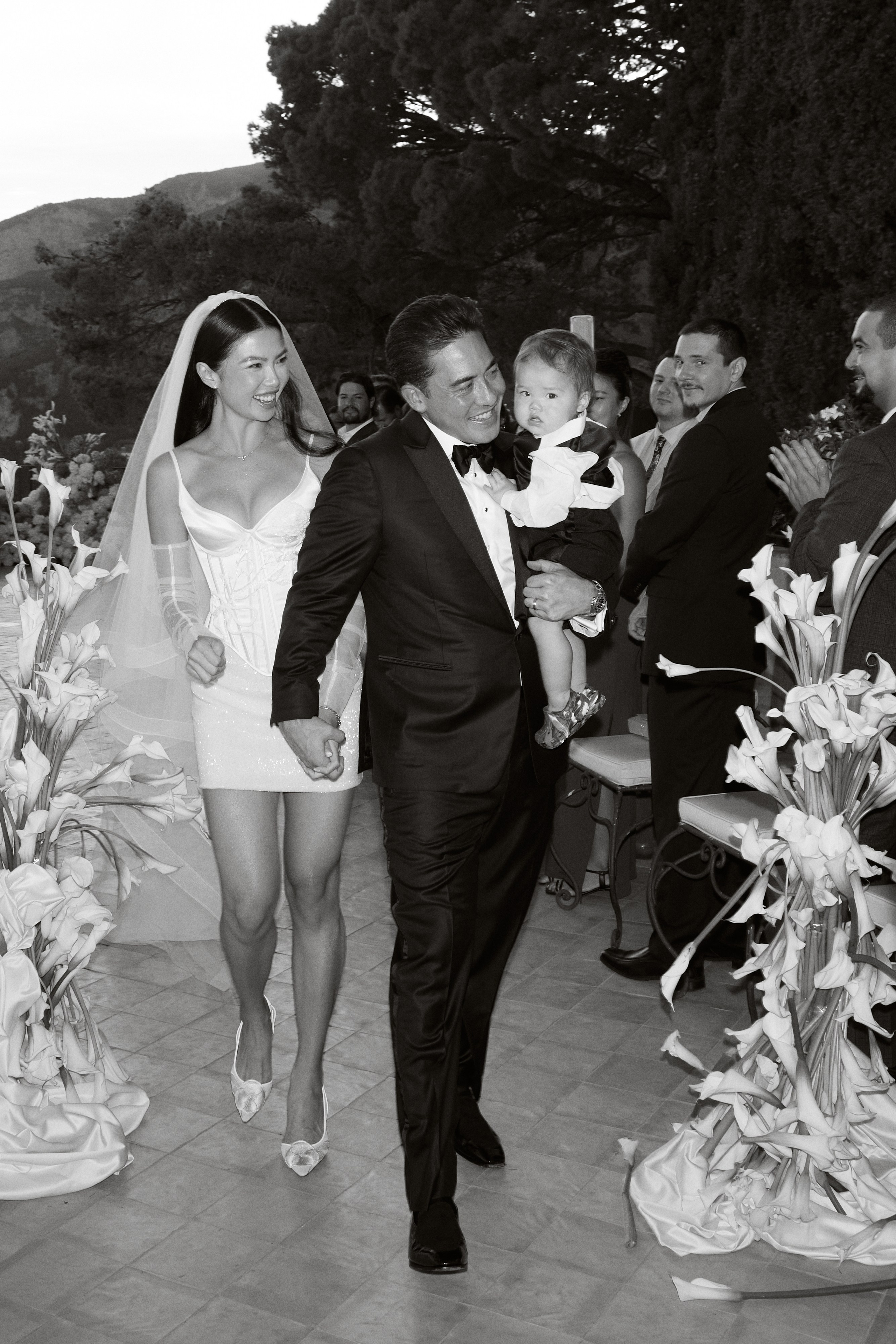 Newlyweds walking back down the aisle in a black and white photograph