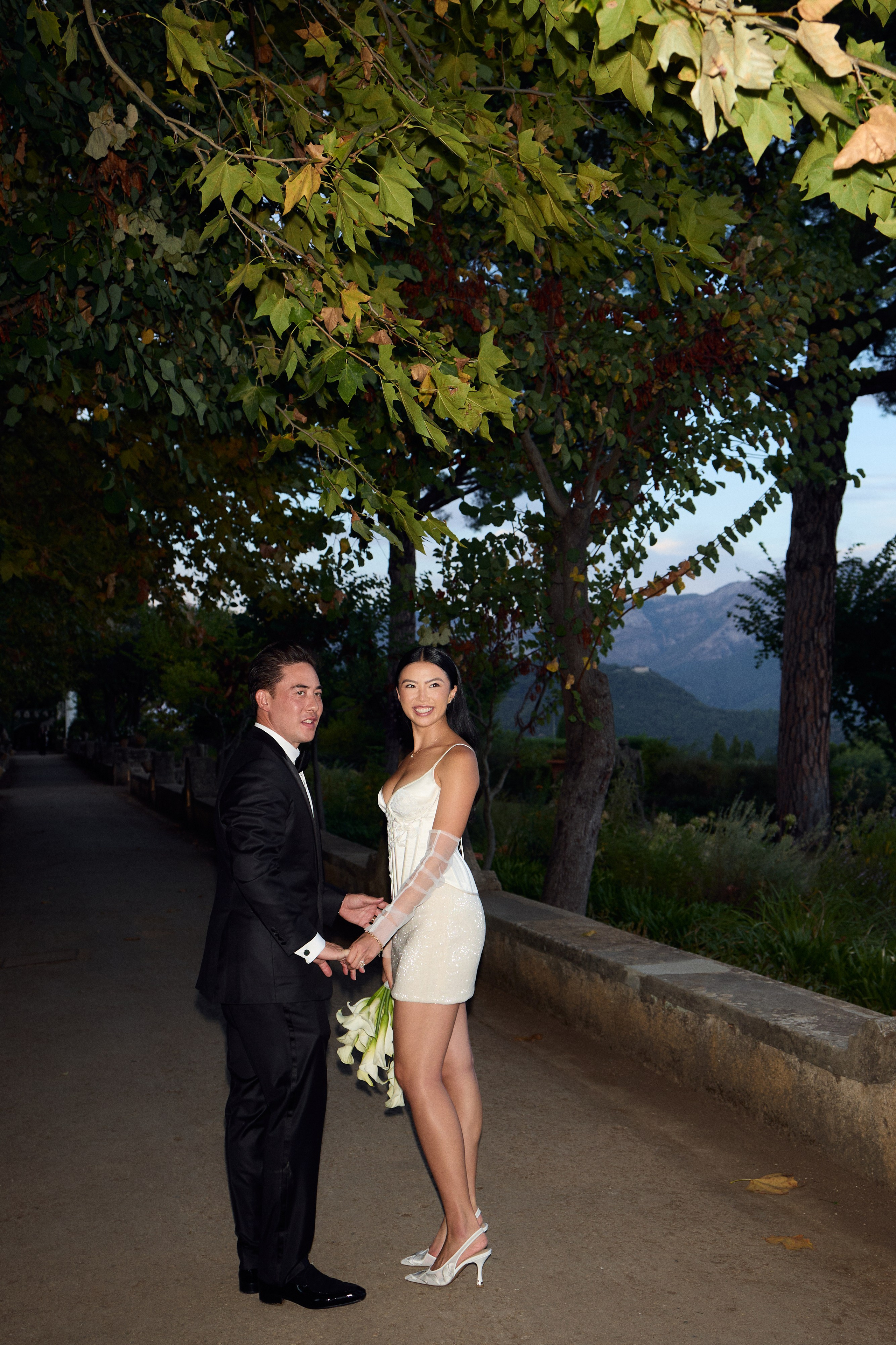Evening portrait of the bride and groom on a garden path 