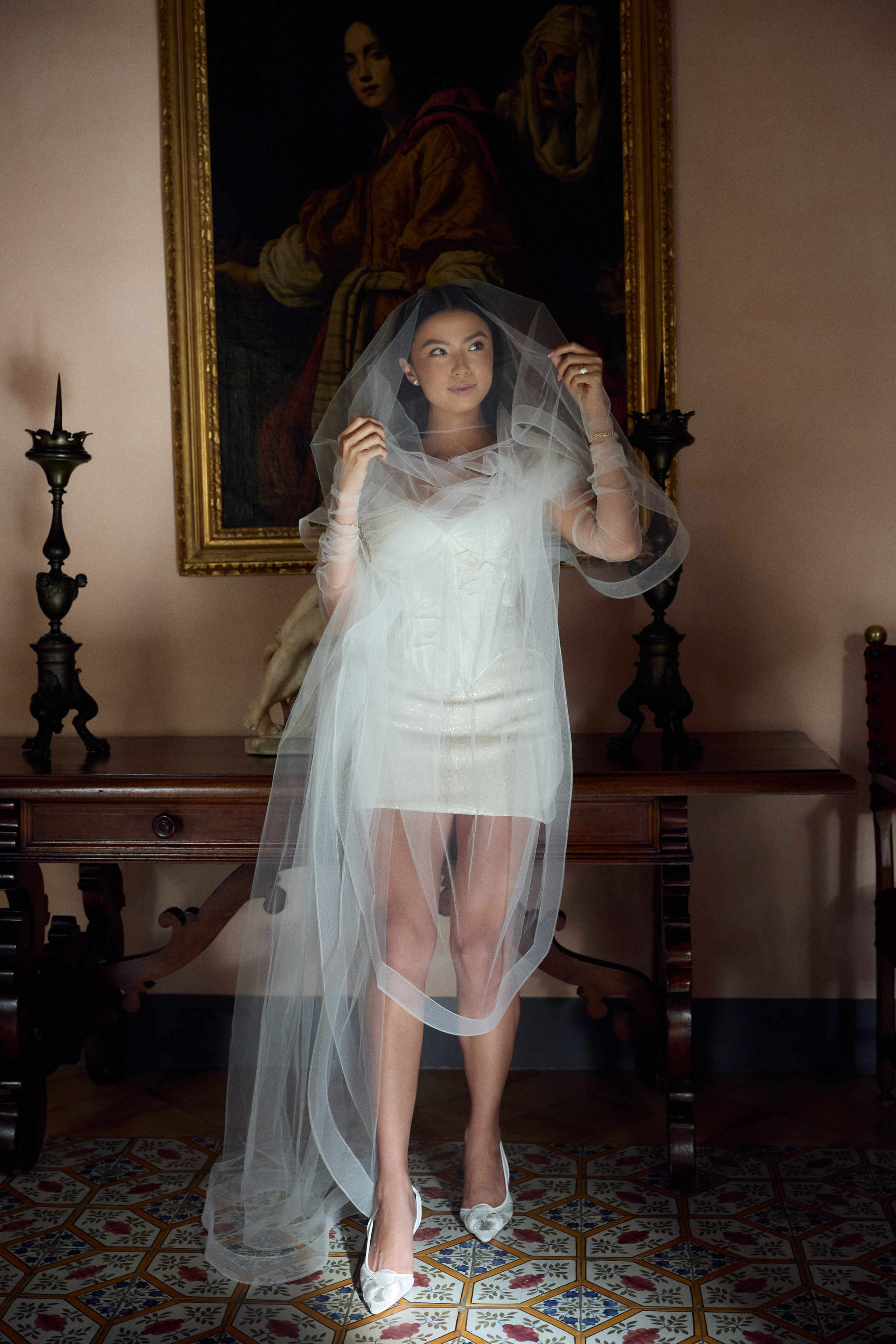 Bride wearing a short wedding dress and long veil inside Villa Cimbrone