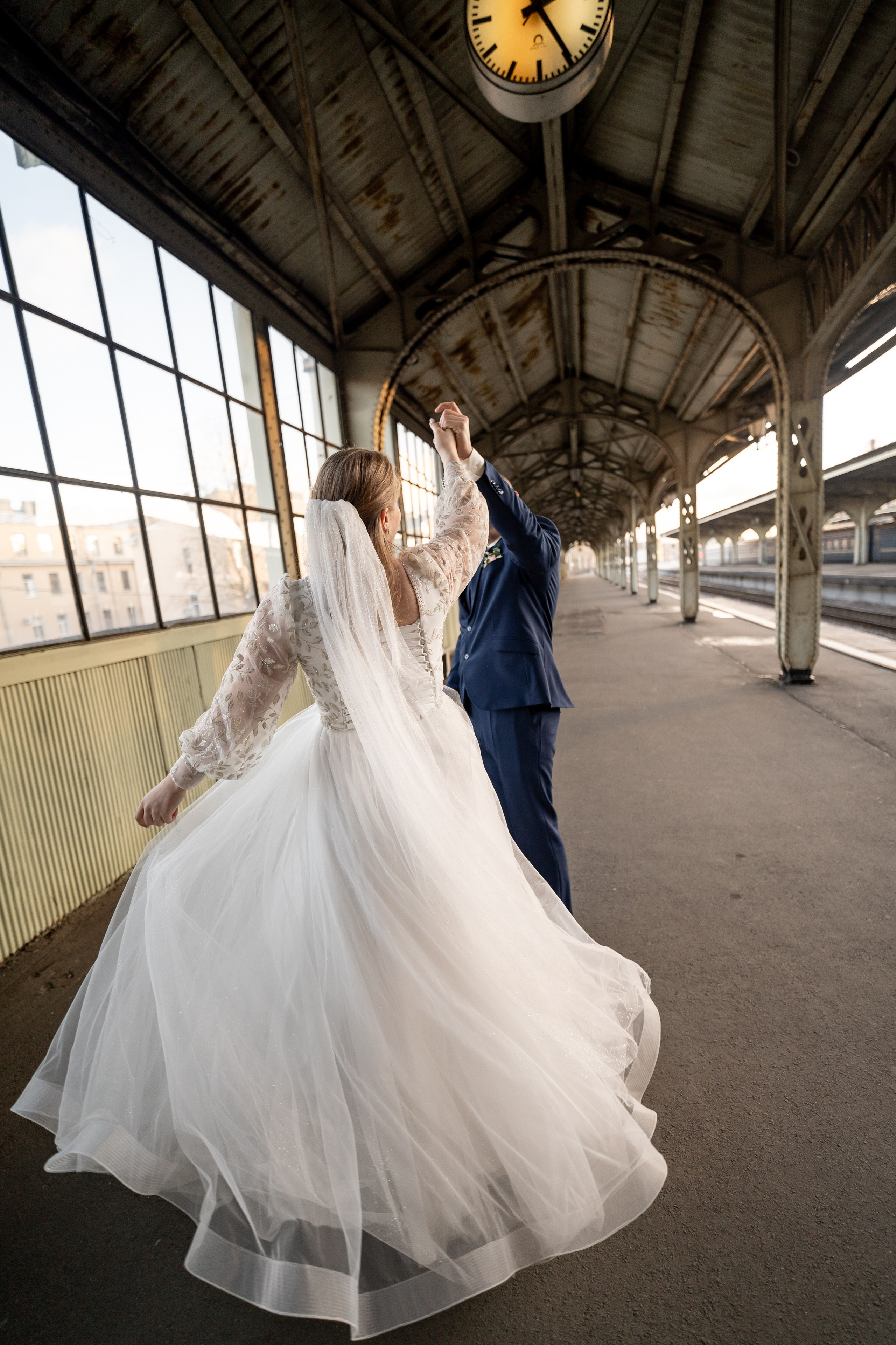 Свадебная фотография на Витебском вокзале в Санкт-Петербурге. Жених и невеста танцуют на перроне