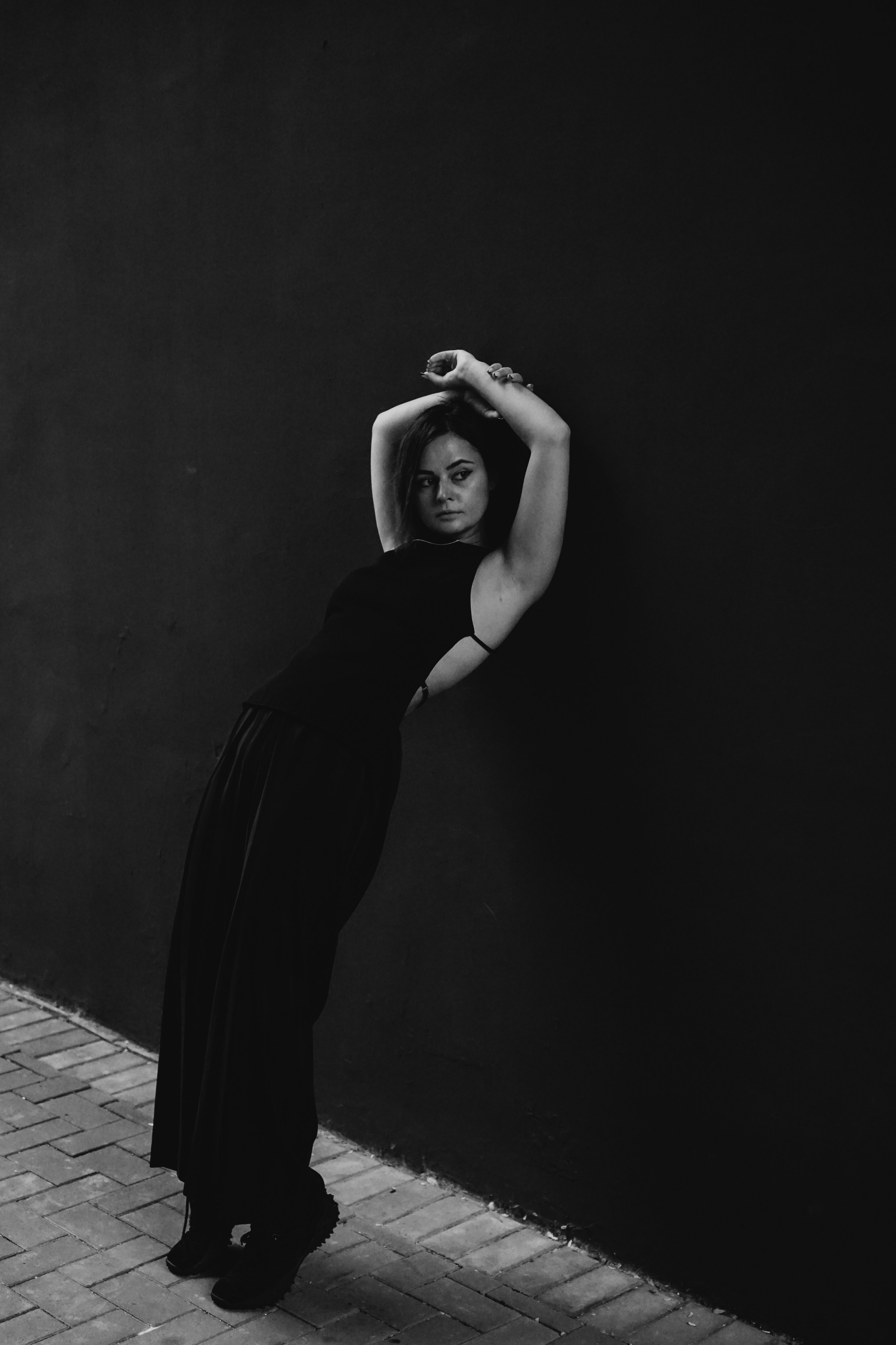 Снимок в полный рост девушку возле стены 