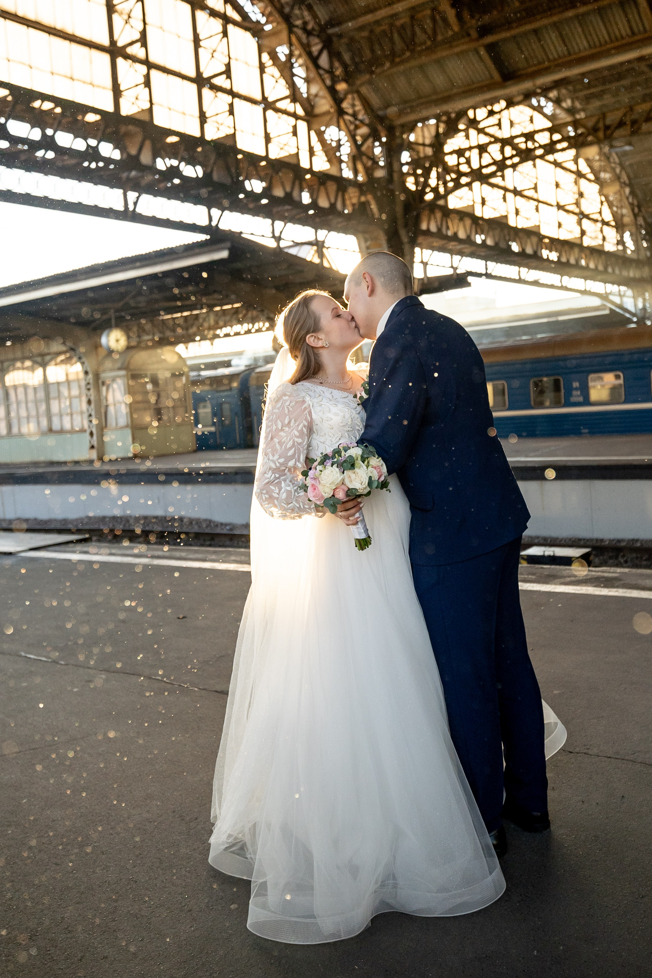 Свадебная фотография на Витебском вокзале в Санкт-Петербурге. Красивый контровой свет подсвечивает снежинки.