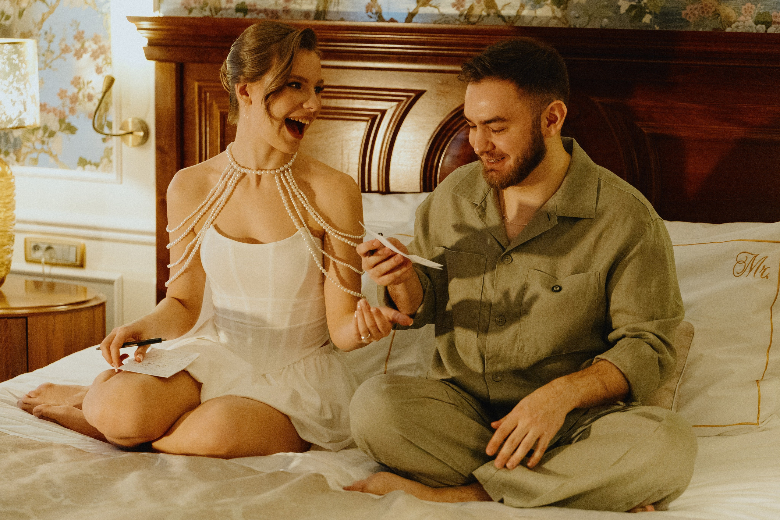 Жених и невеста сидят на кровати, смотрят друг на друга.