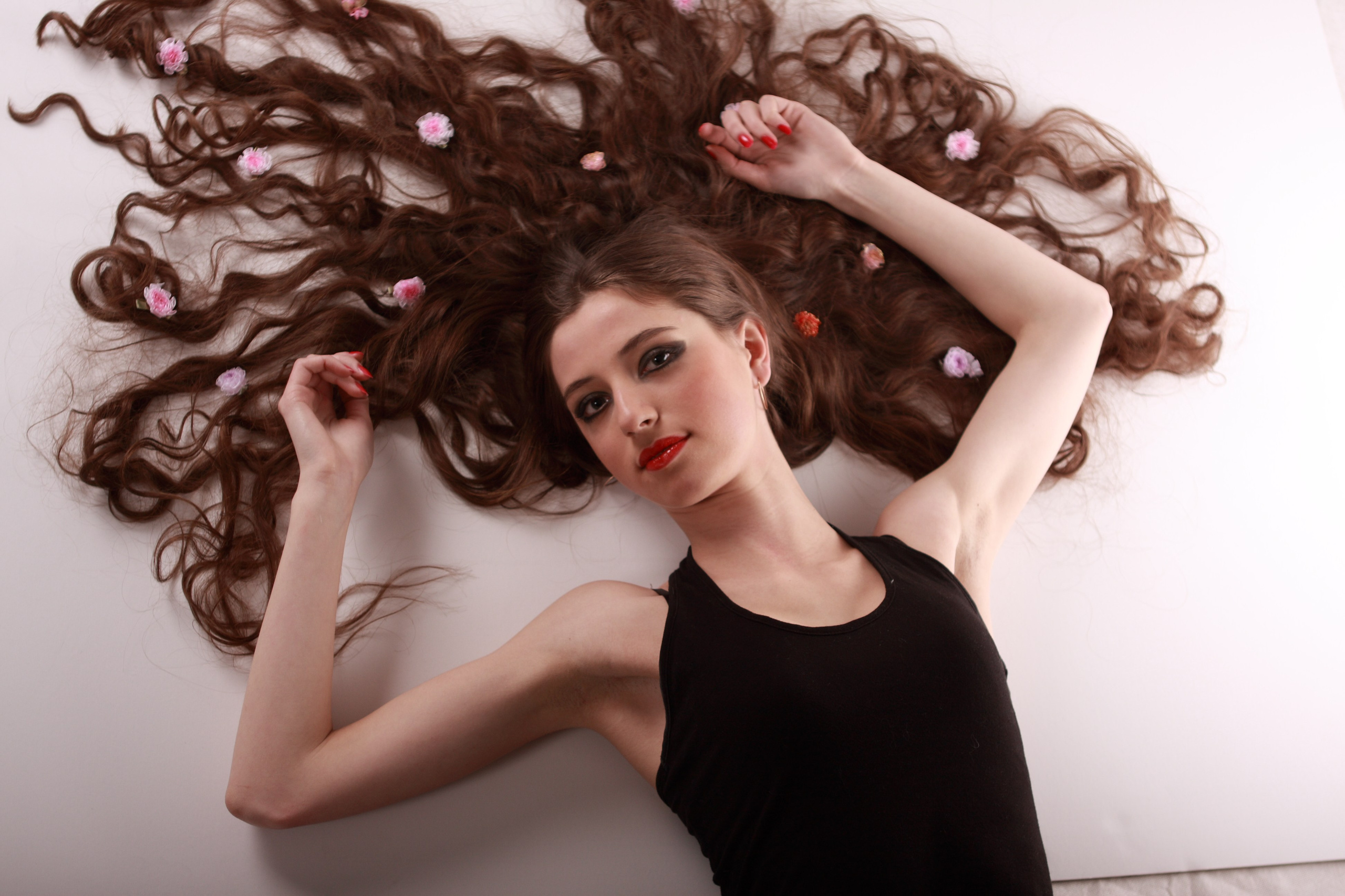 индивидуальная фотосьемка в студии где девушка лежит на полу с распущенными длинными волосами 