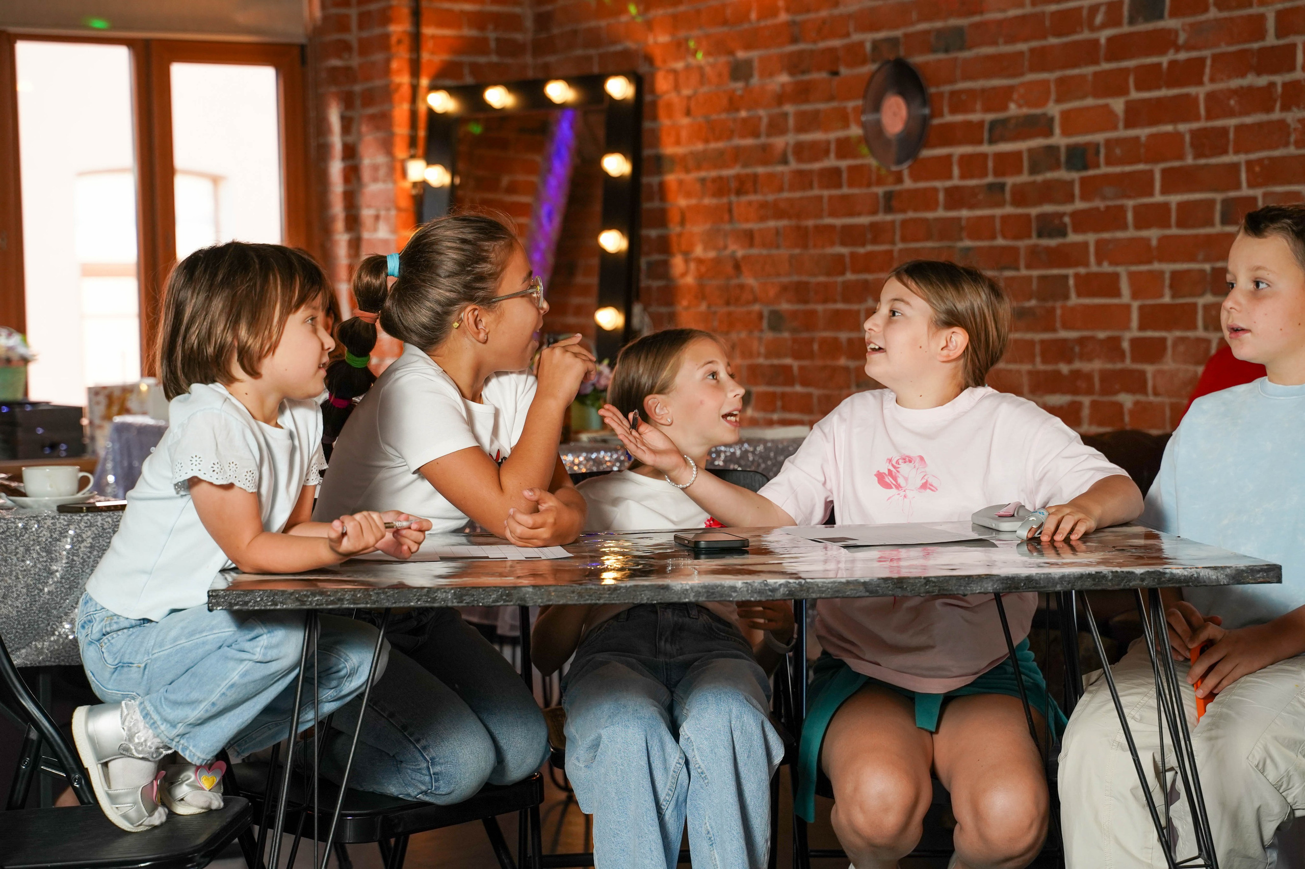 Команда детей за столом играет в квиз