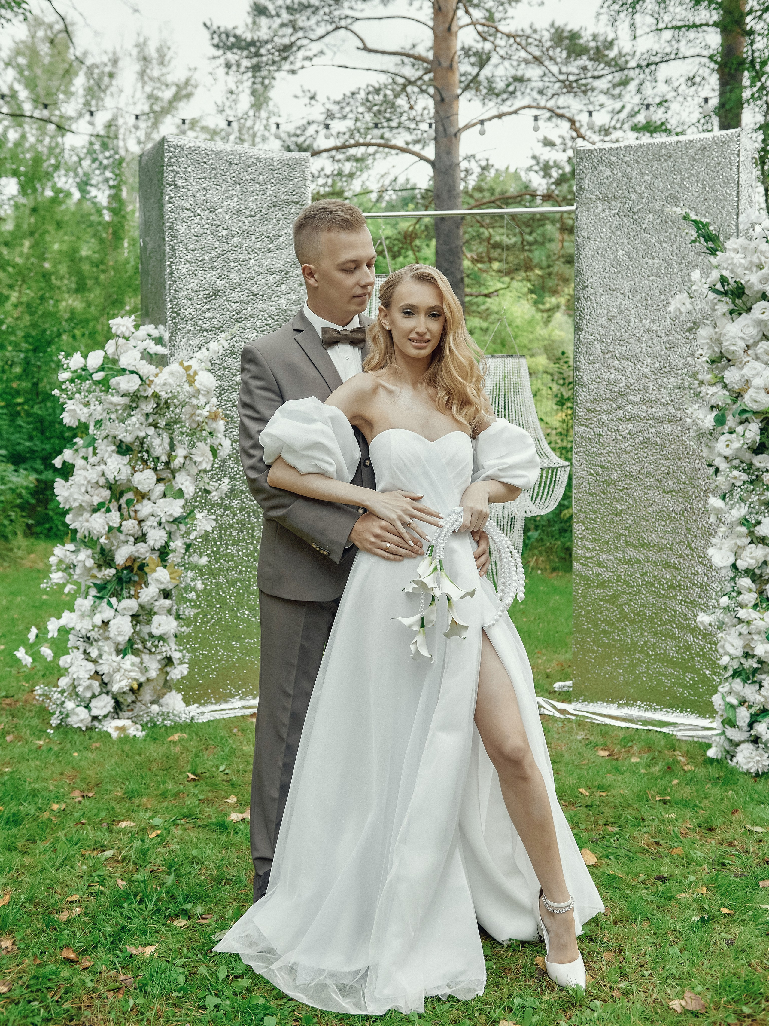 Свадебная пара у арки на выездной регистрации в экохаусе в лесу»