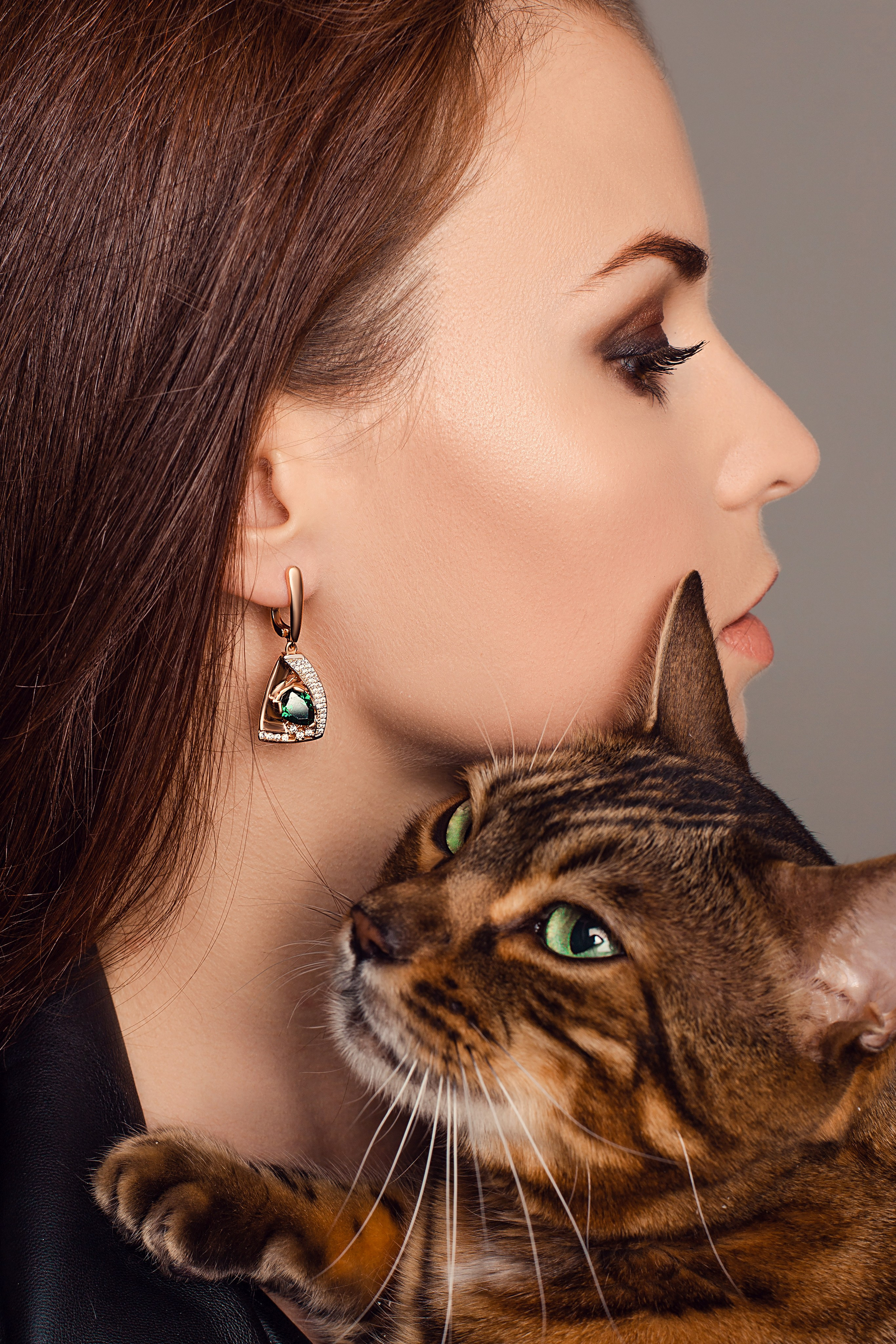 абиссинская порода кошки на руках у девушки в фотостудии