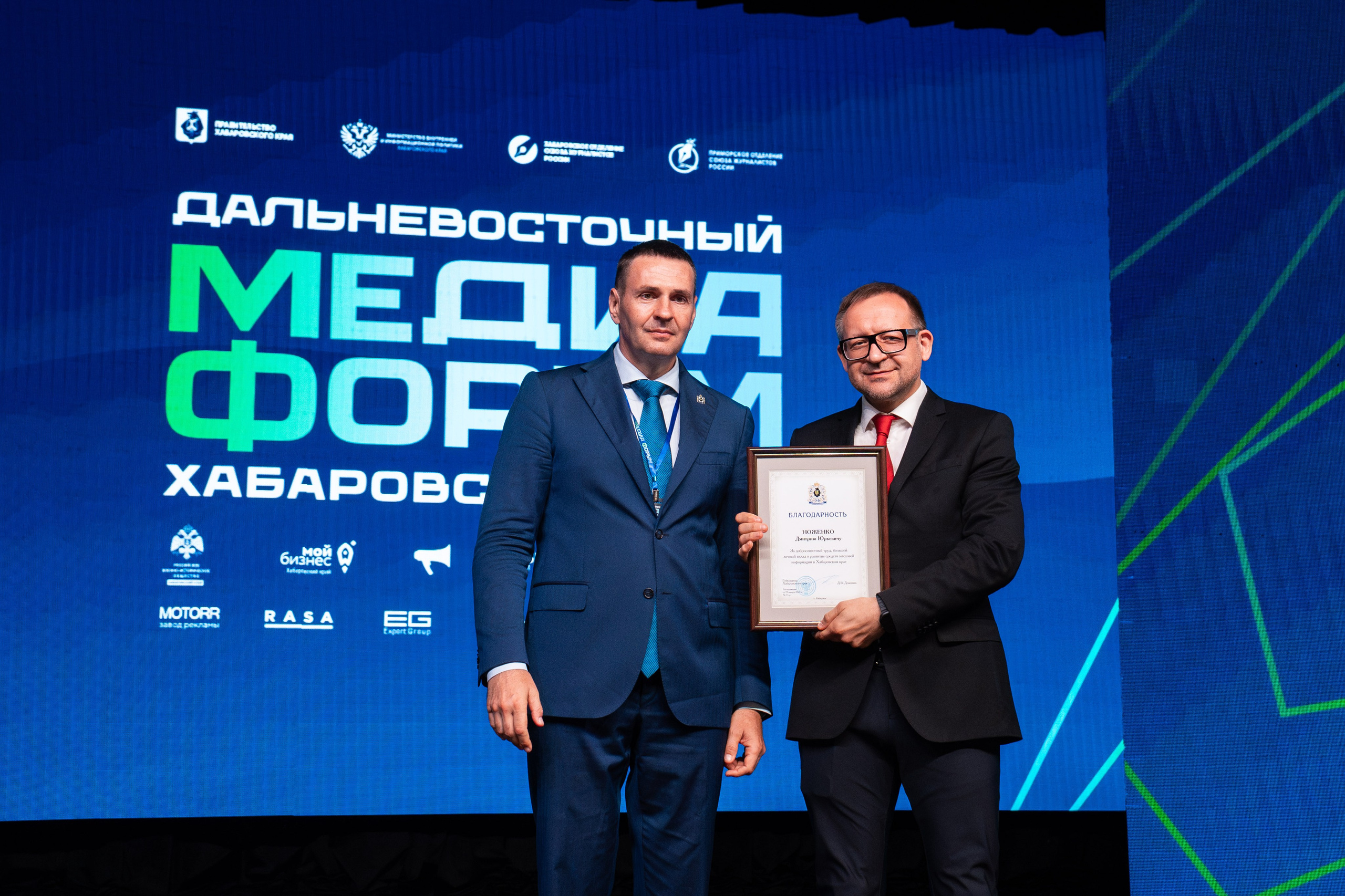 Портрет участников в деловых костюмах на фоне экрана от репортажного фотографа в Хабаровске Дмитрия Дергачева на Дальневосточном медиафоруме.