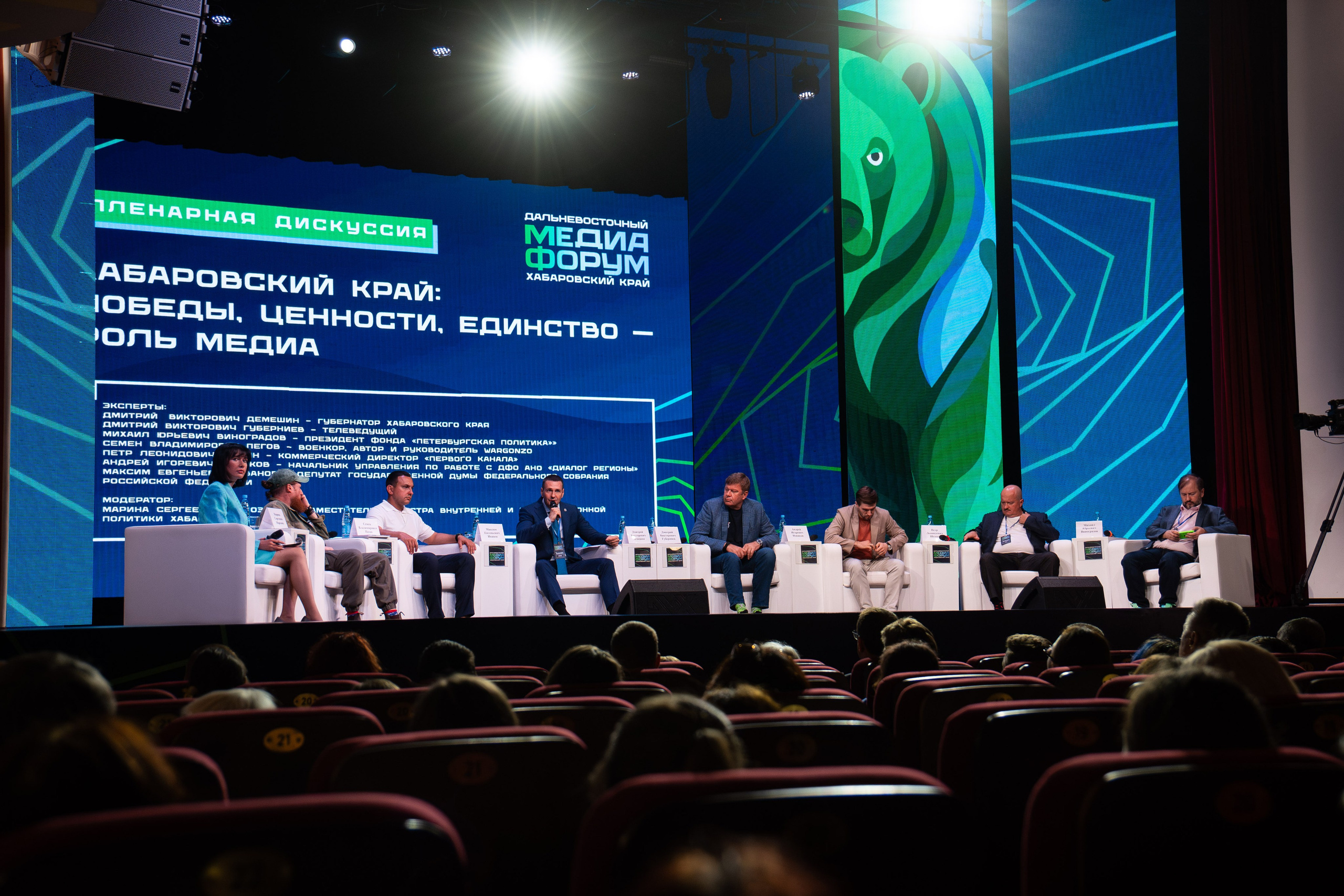 Репортажный фотограф в Хабаровске Дмитрий Дергачев снял общий план большого зала с экраном и выступающими на сцене Дальневосточного медиафорума.