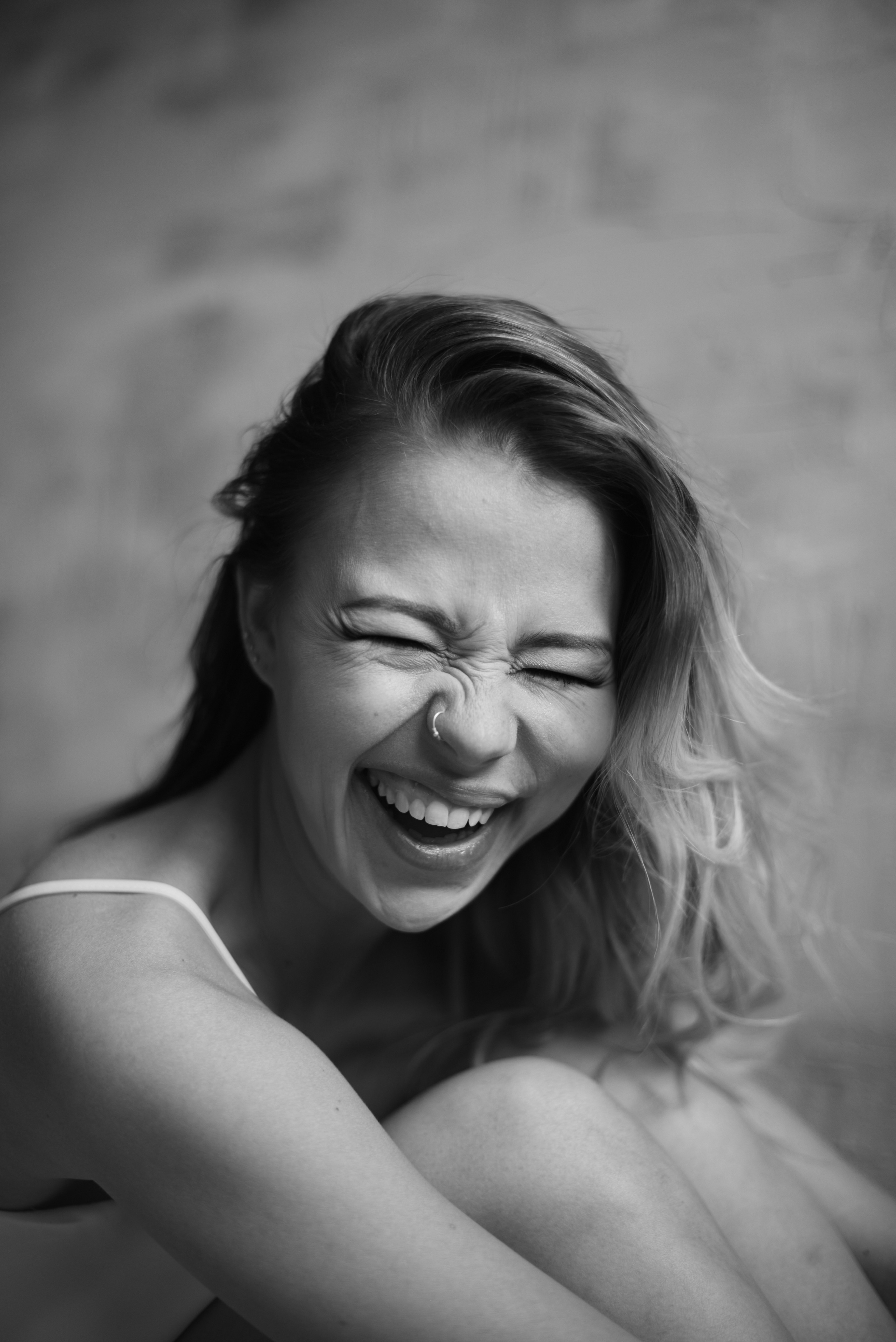 Черно-белый портрет девушка смеётся и обнимает колени