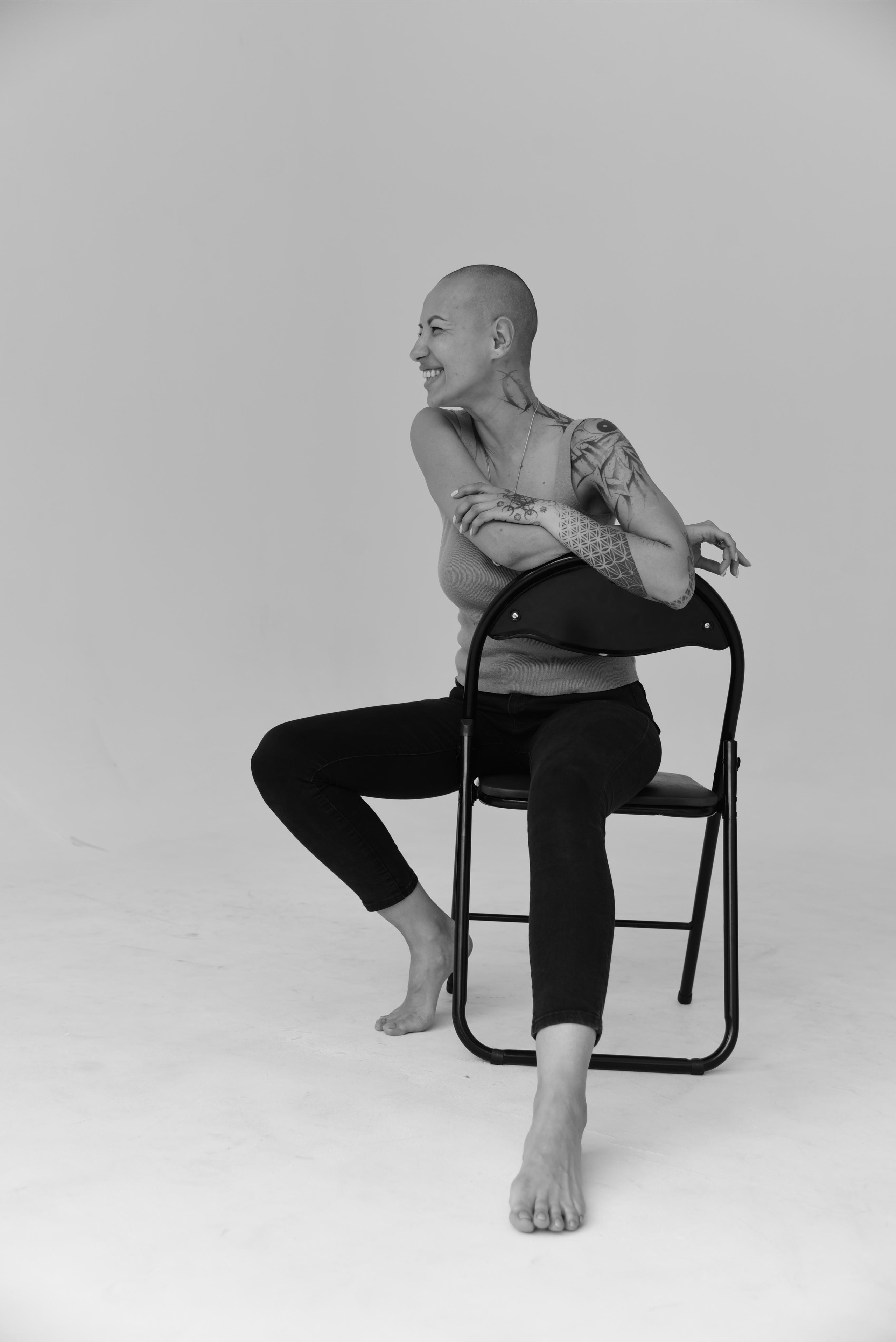 фотосессия на циклораме на стуле лысая девушка смеется