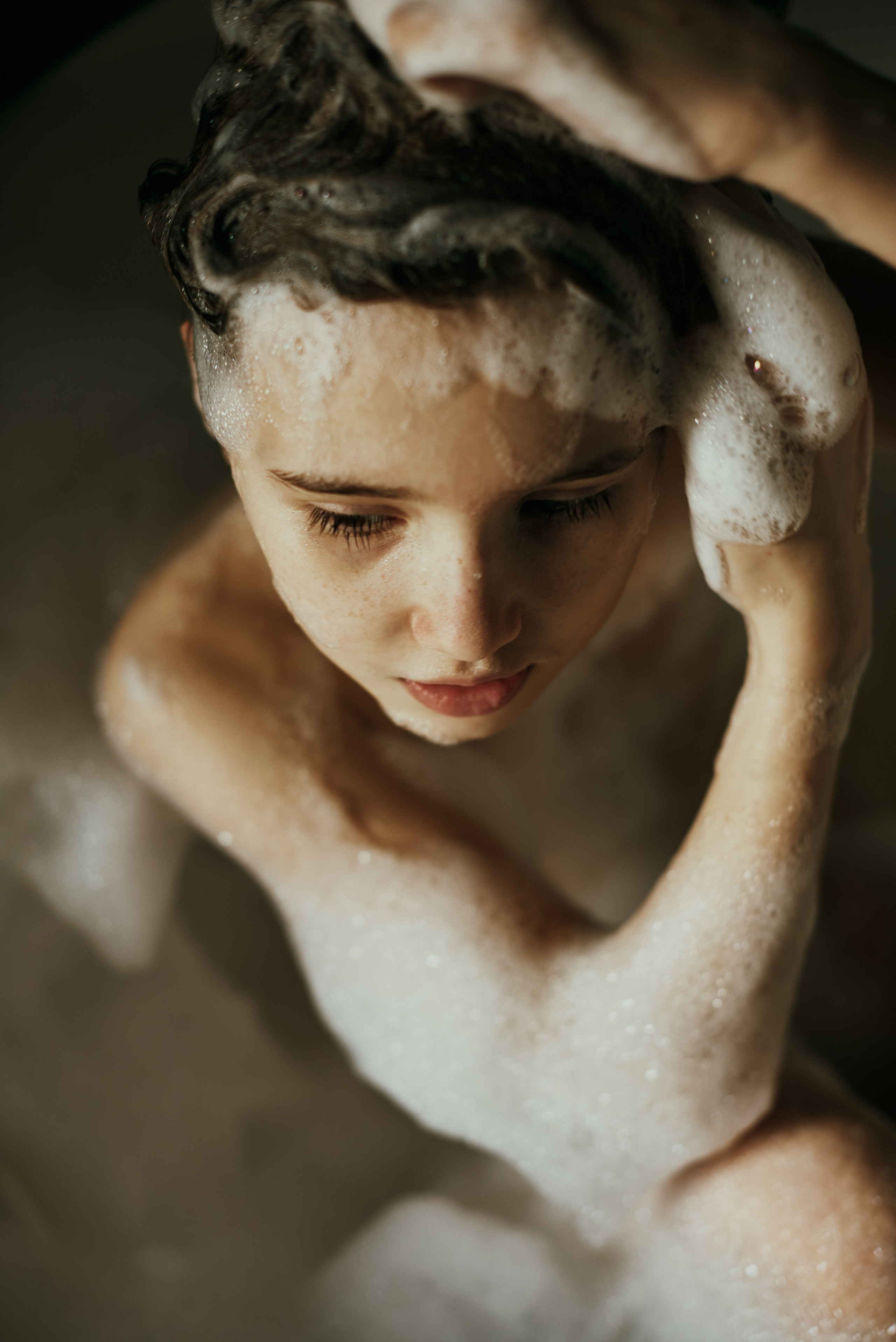 Портрет девочка в ванне с пеной моет голову