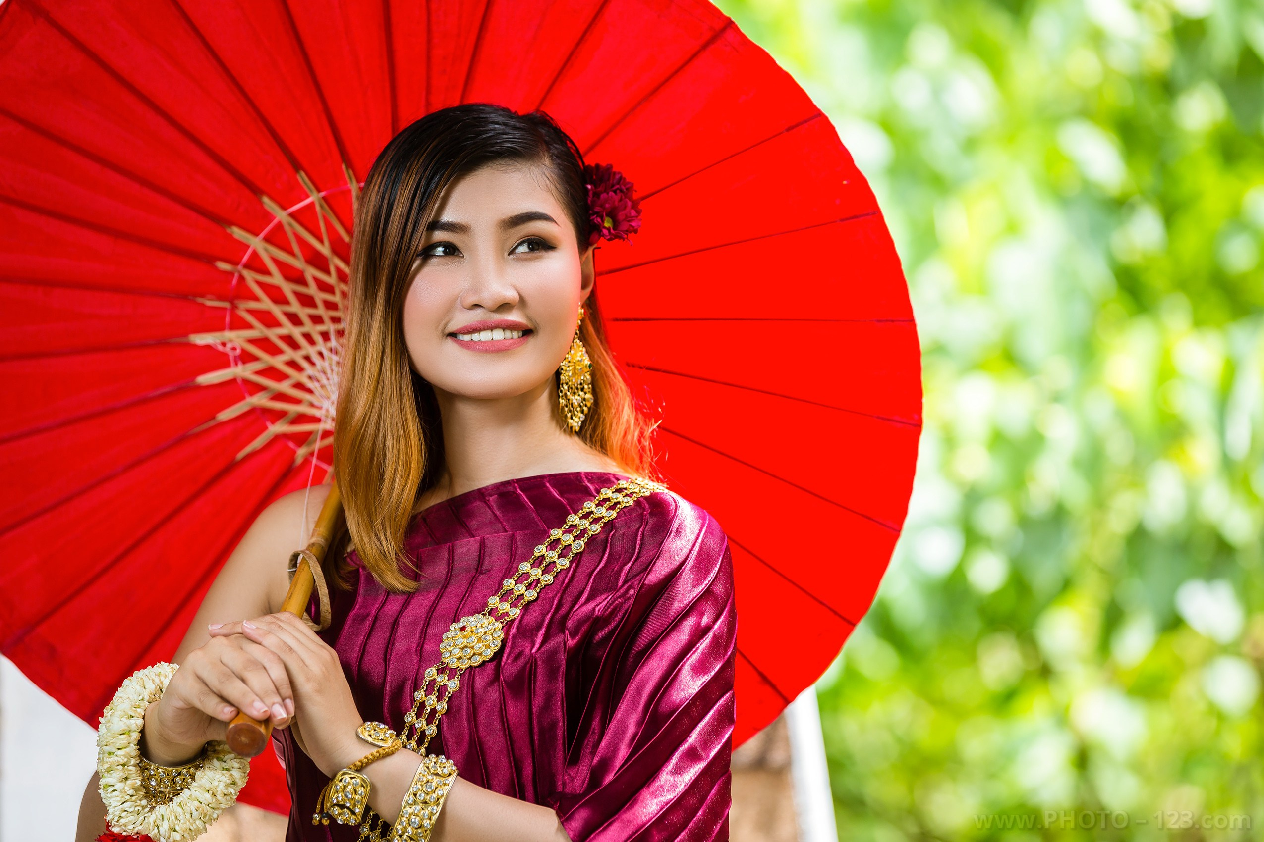 Thai woman in traditional costume with red umbrella, portrait photography 