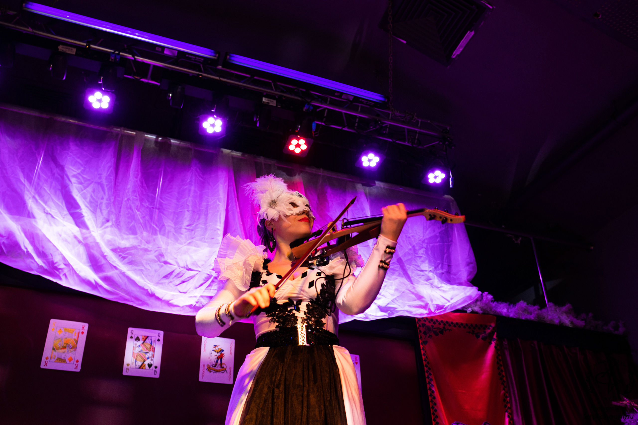 Девушка играет на скрипке на сцене.