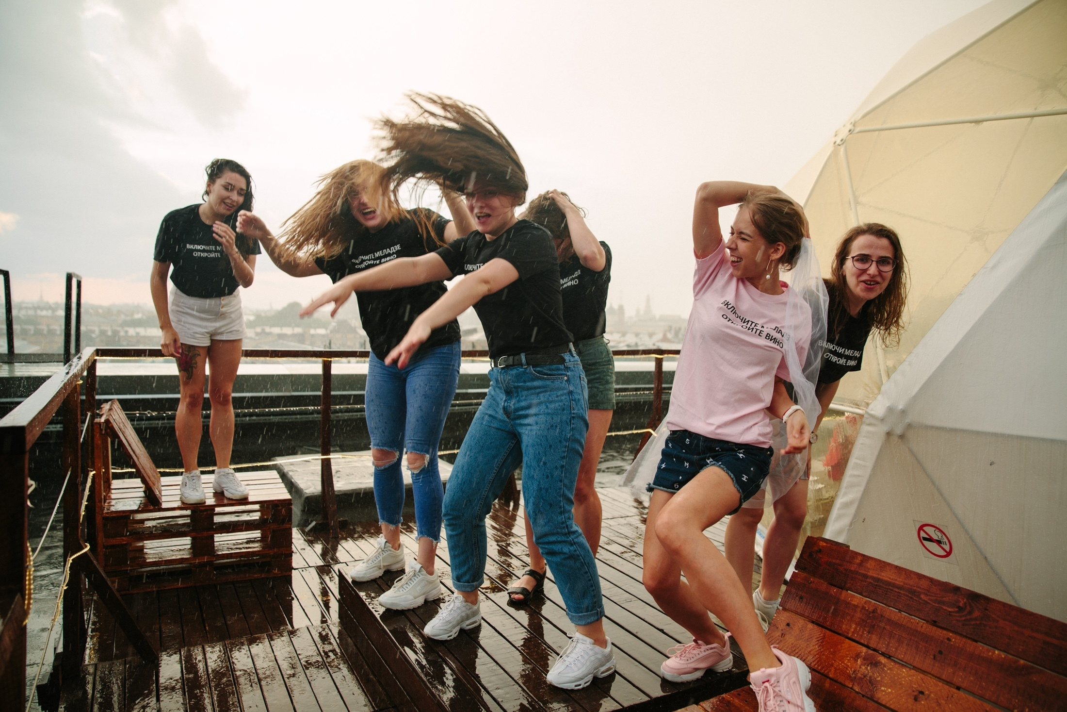 Фотография Девичник на крыше Петербург  групповой снимок с подружками невесты под дождем