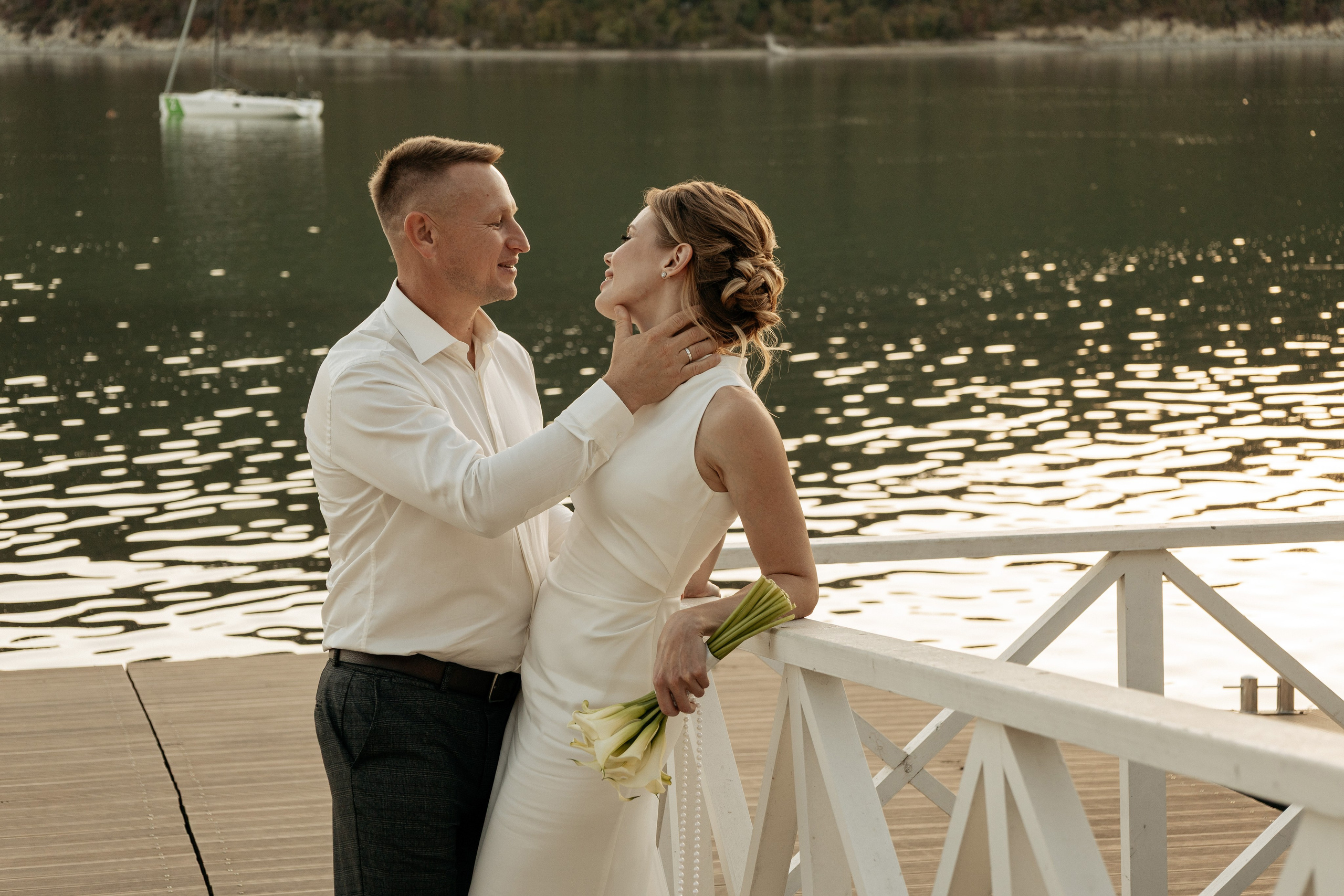 Жених нежно поддерживает невесту на склоне зеленого холма