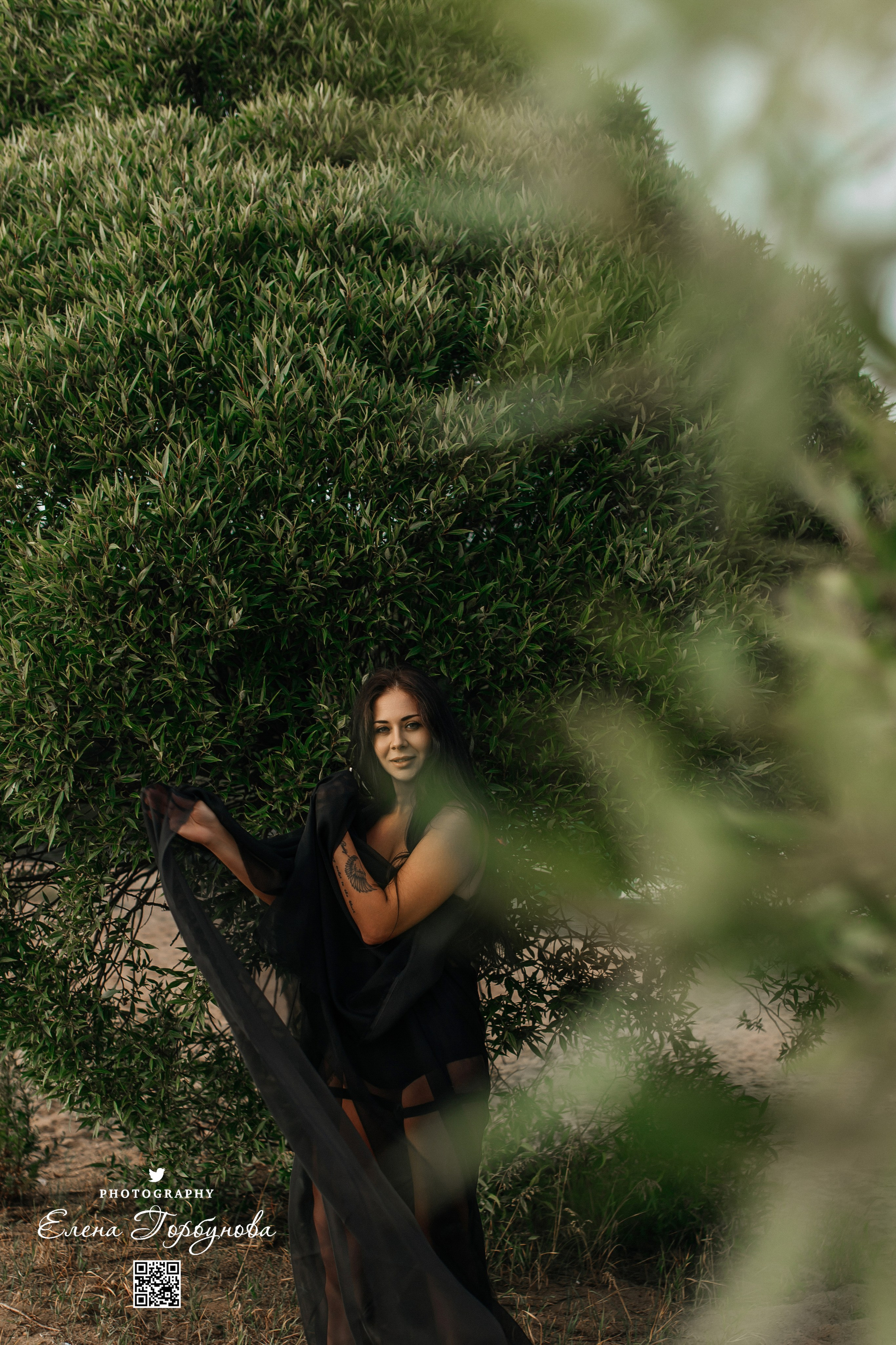 Девушка фотографирутся в листьях ивы