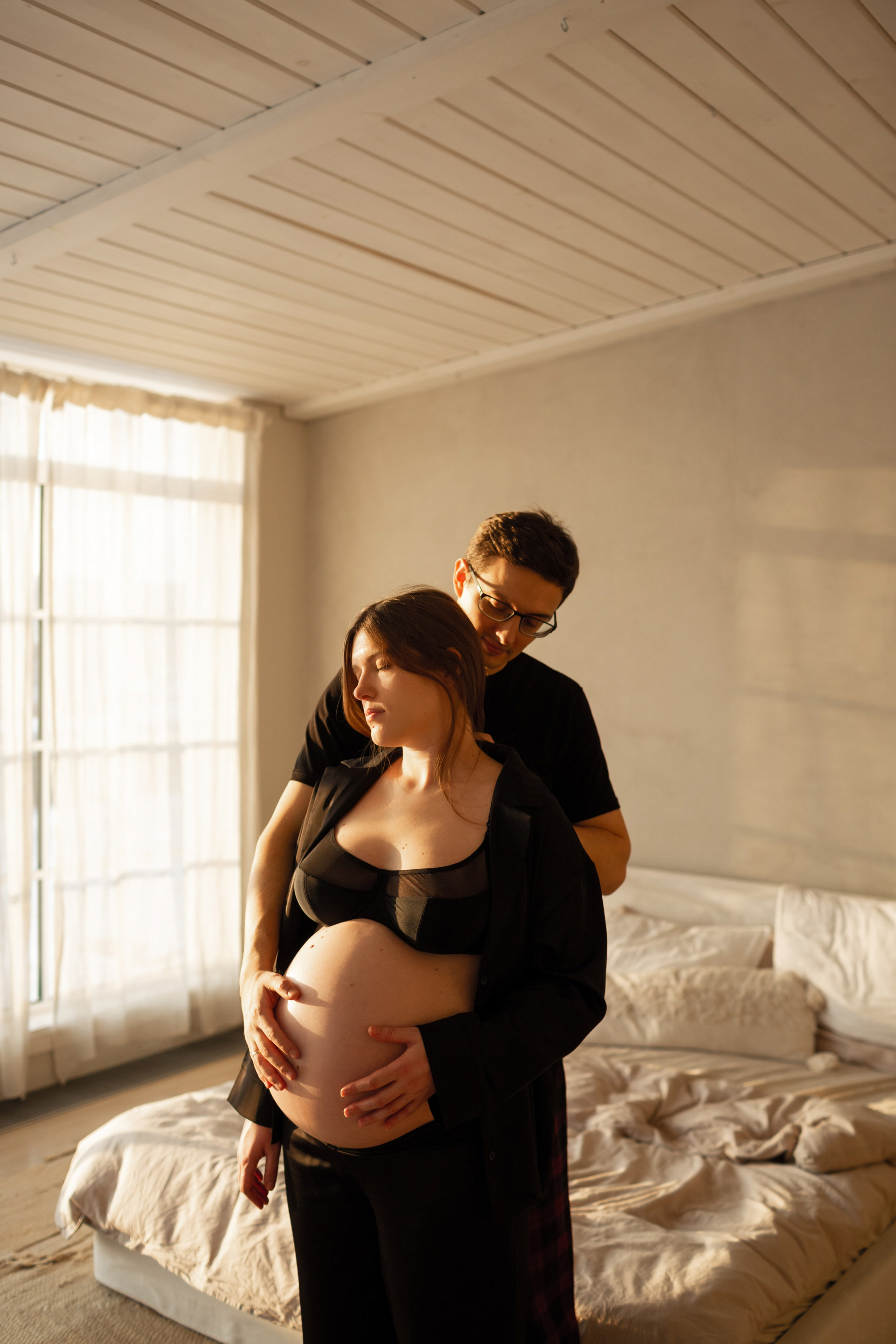 Красивая беременная пара на фотосессии в черных пижамах