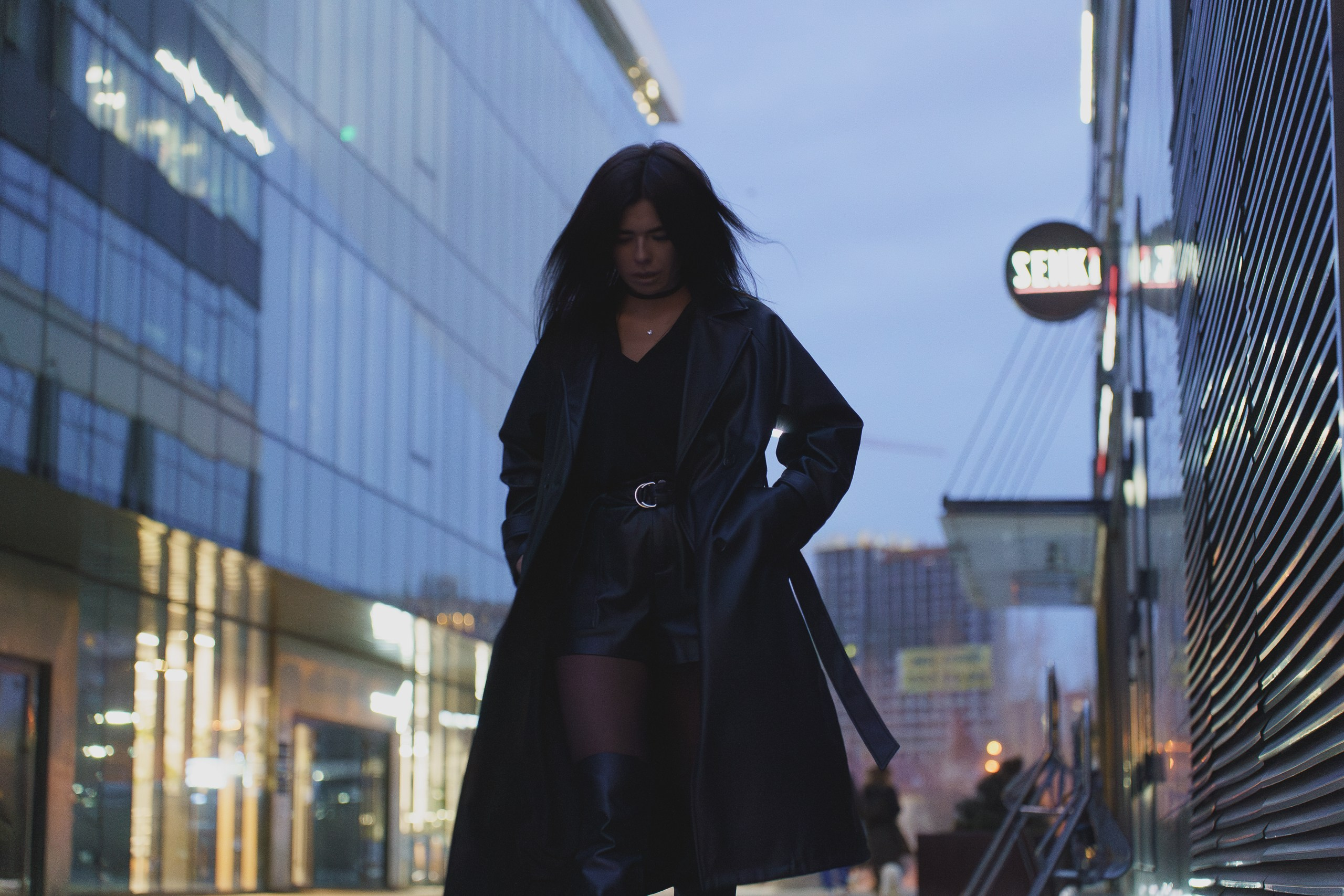 Портрет в ночном городе на фоне неона и стеклянных фасадов