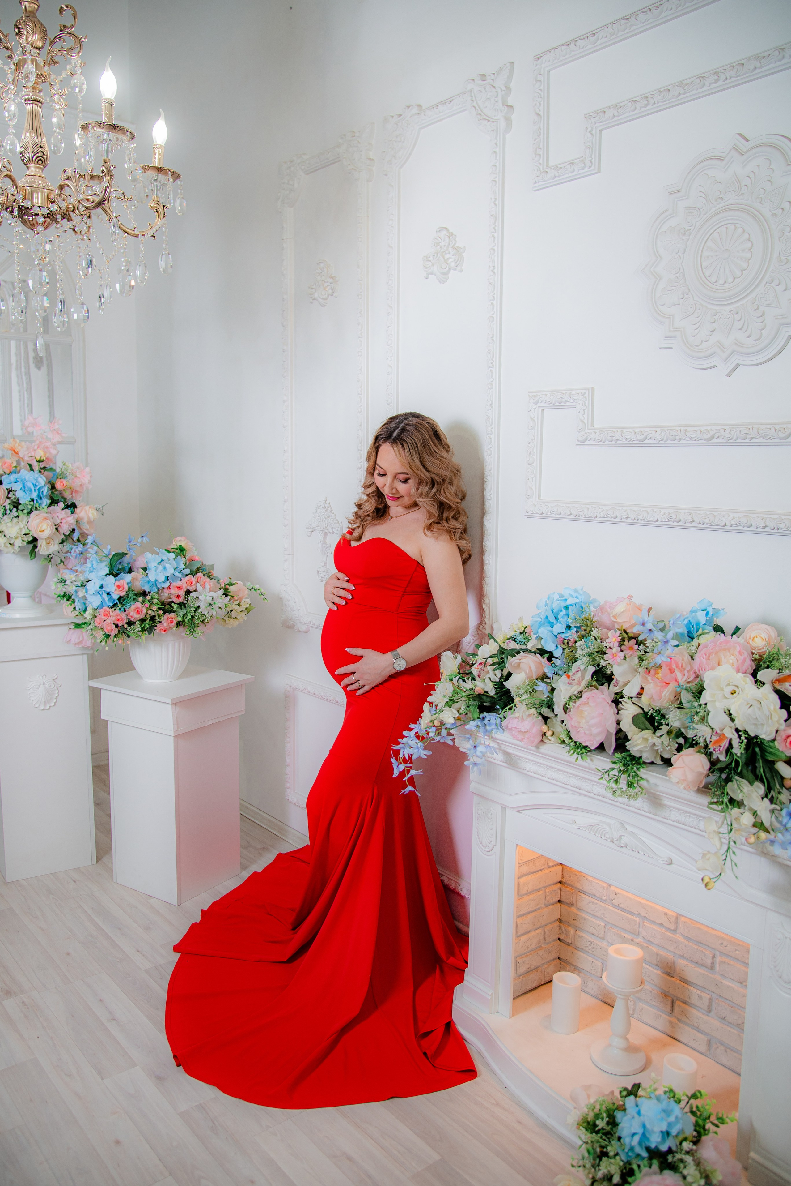 Фотосессия беременных в фотостудии в Уфе: будущая мама в элегантном платье из проката, с профессиональным макияжем и прической. Она счастливо позирует на фоне стильного интерьера, отражая красоту и нежность материнства.