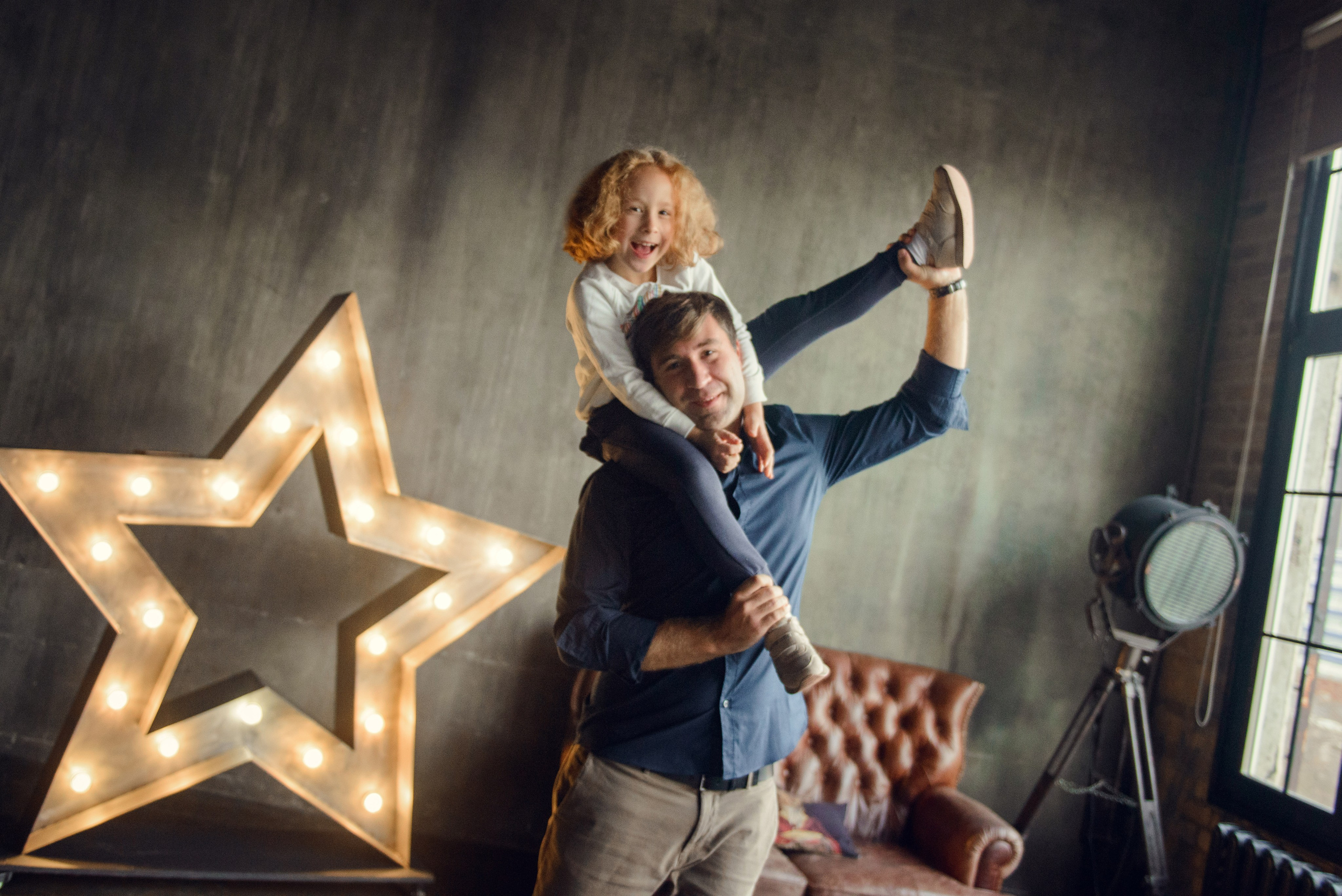 dad and daughter in a dark photo studio