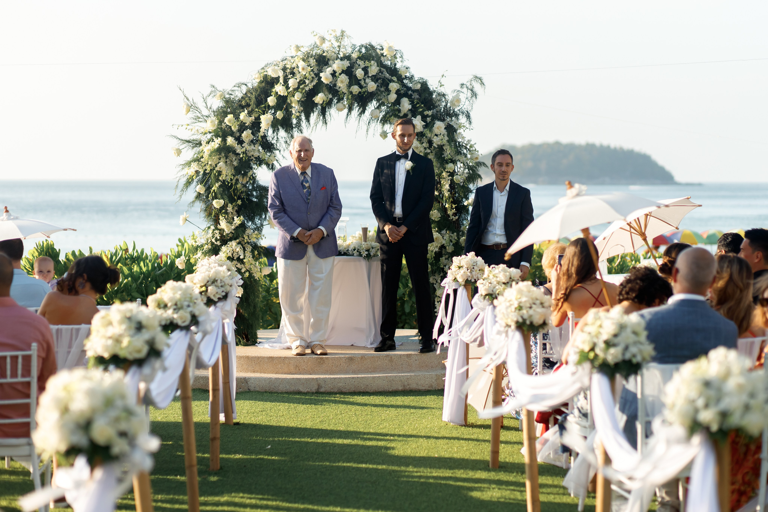 жених ждет невесту у алтаря на фоне моря 