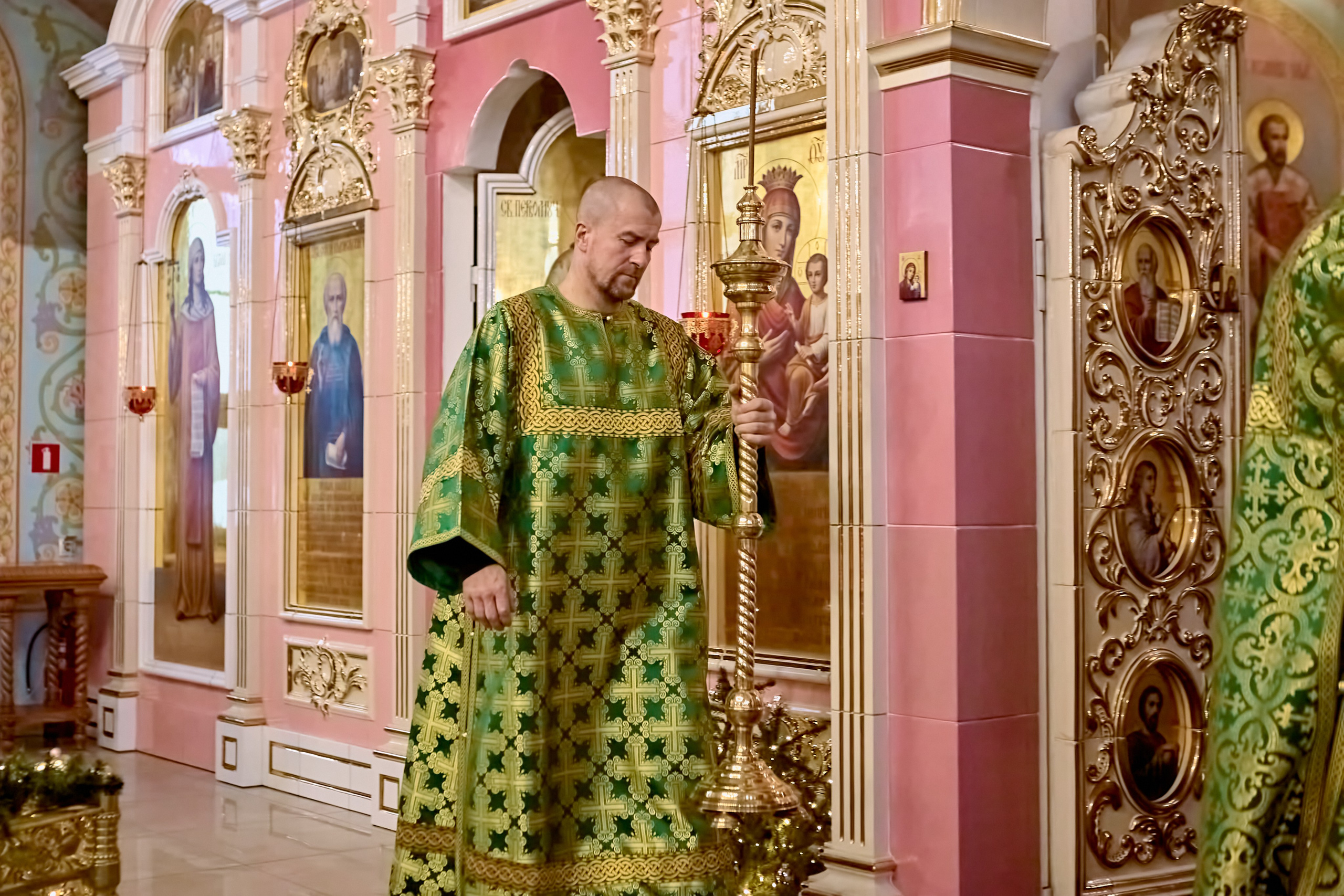 Алтарник выносит свечу перед чтением Евангелия