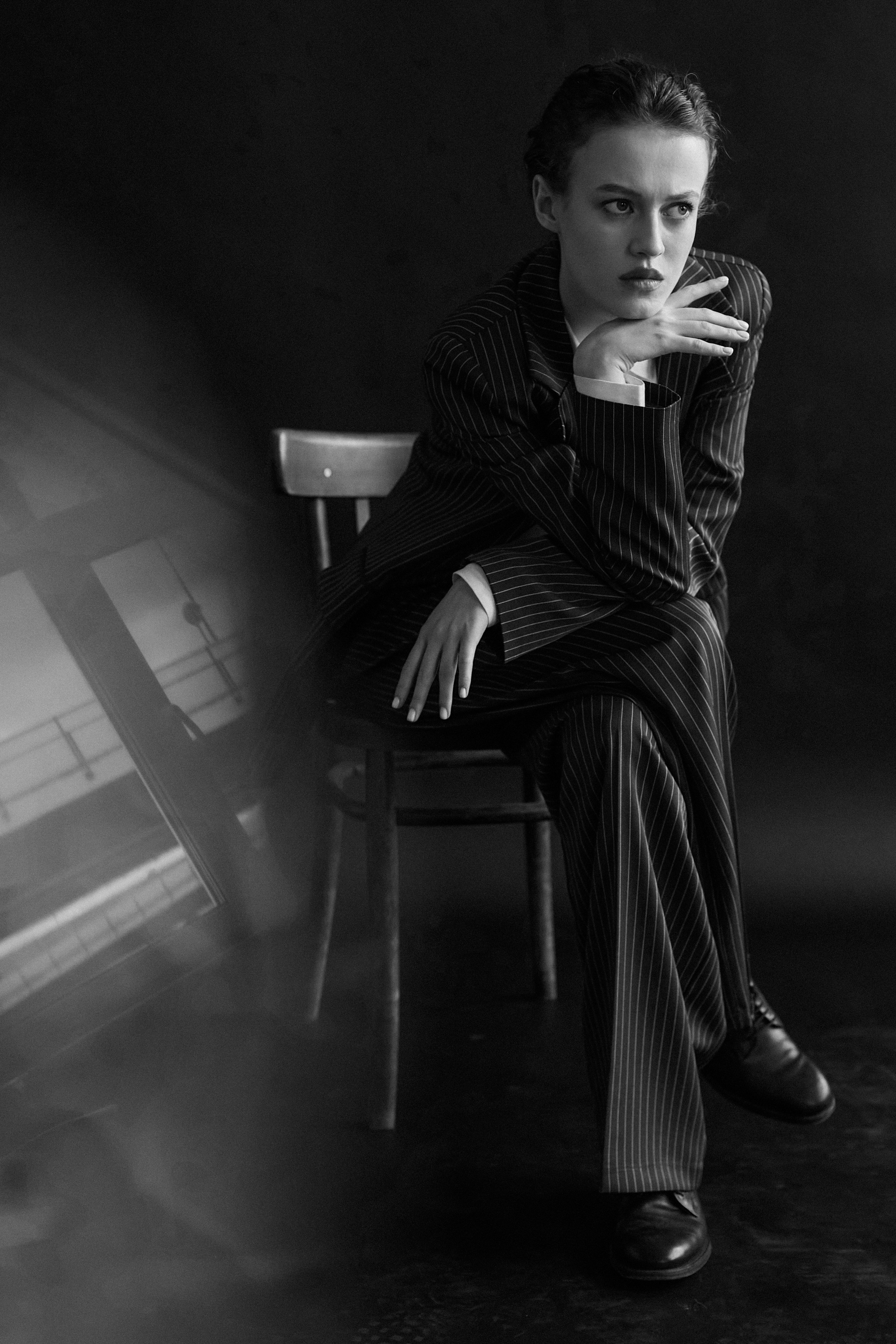 Фотограф в Москве. Студия. Студийный портрет. Девушка в пиджаке. Девушка на стуле на черном фоне. Красивая девушка в мужском костюме. Женский портрет. Черно-белое фото.