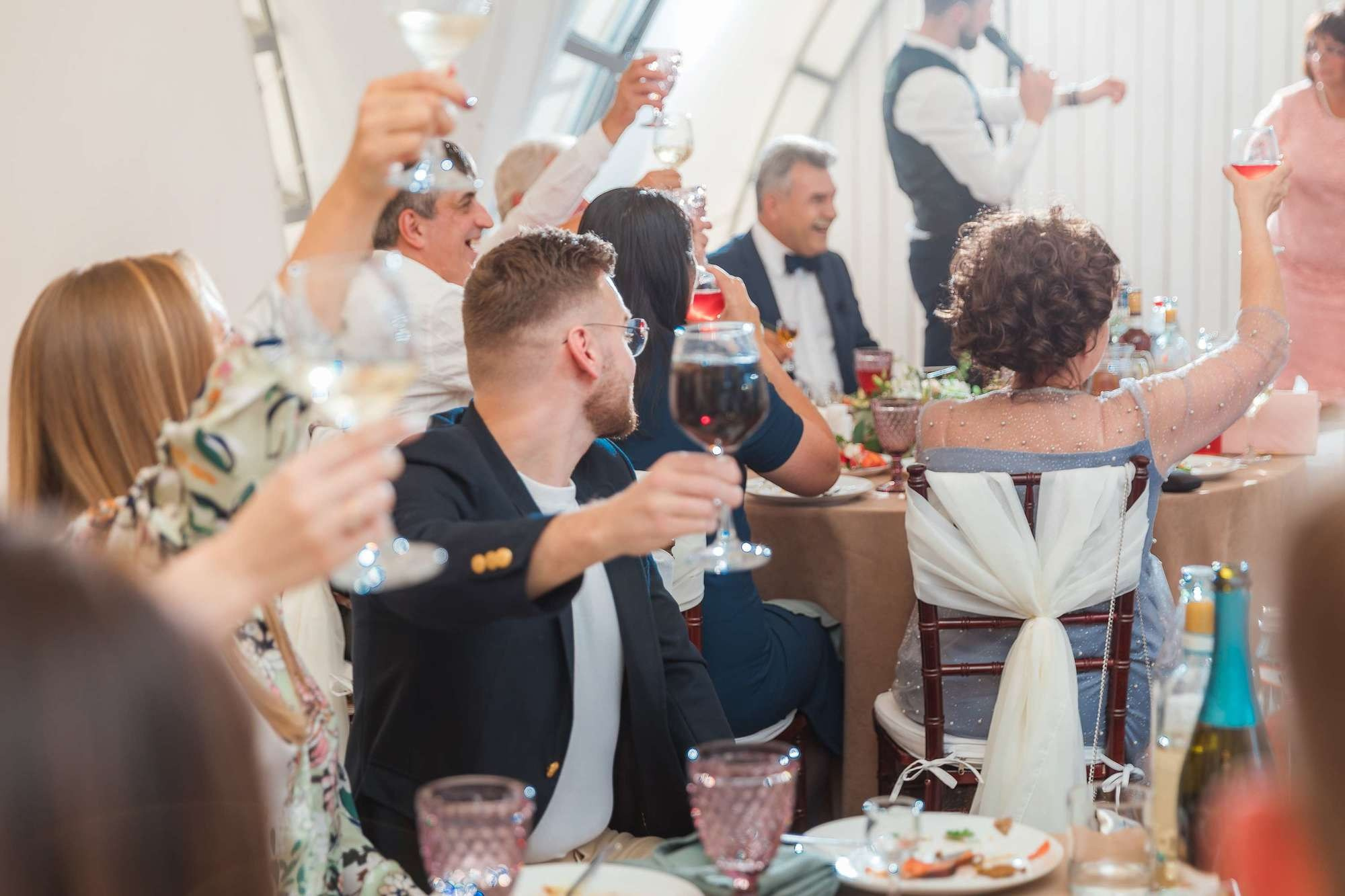 Гости поднимают бокалы на свадьбе