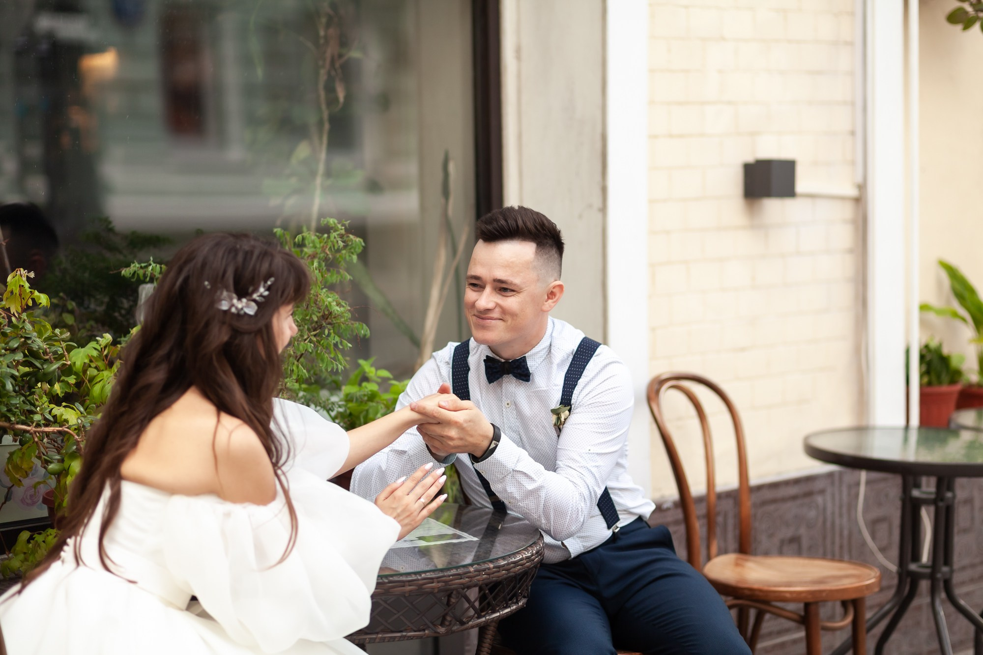 Молодожены сидят взявшись за руки