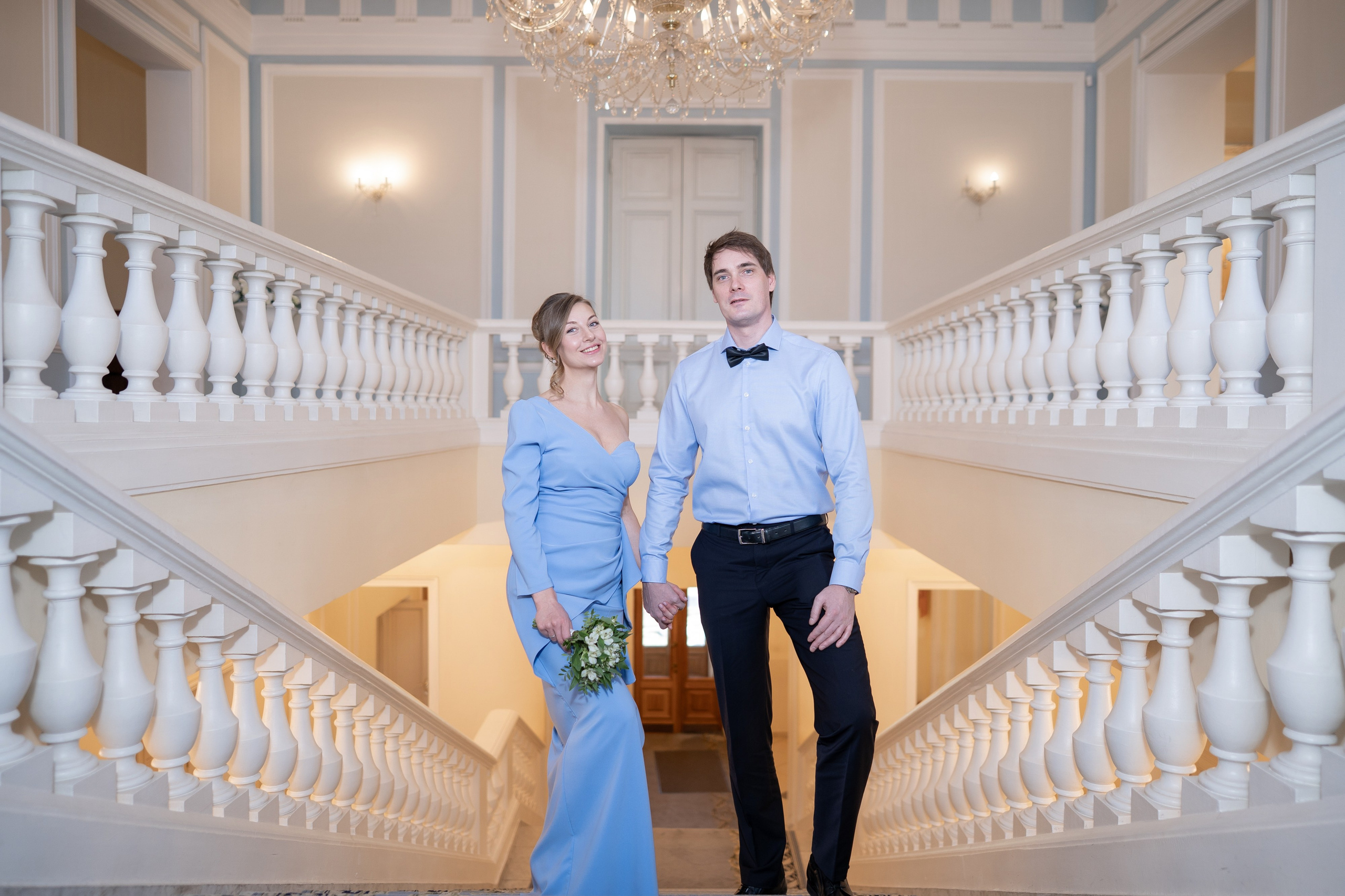 Свадебная фотосессия в ЗАГСе Кировского района. Жених и невеста на парадной лестнице позируют фотографу
