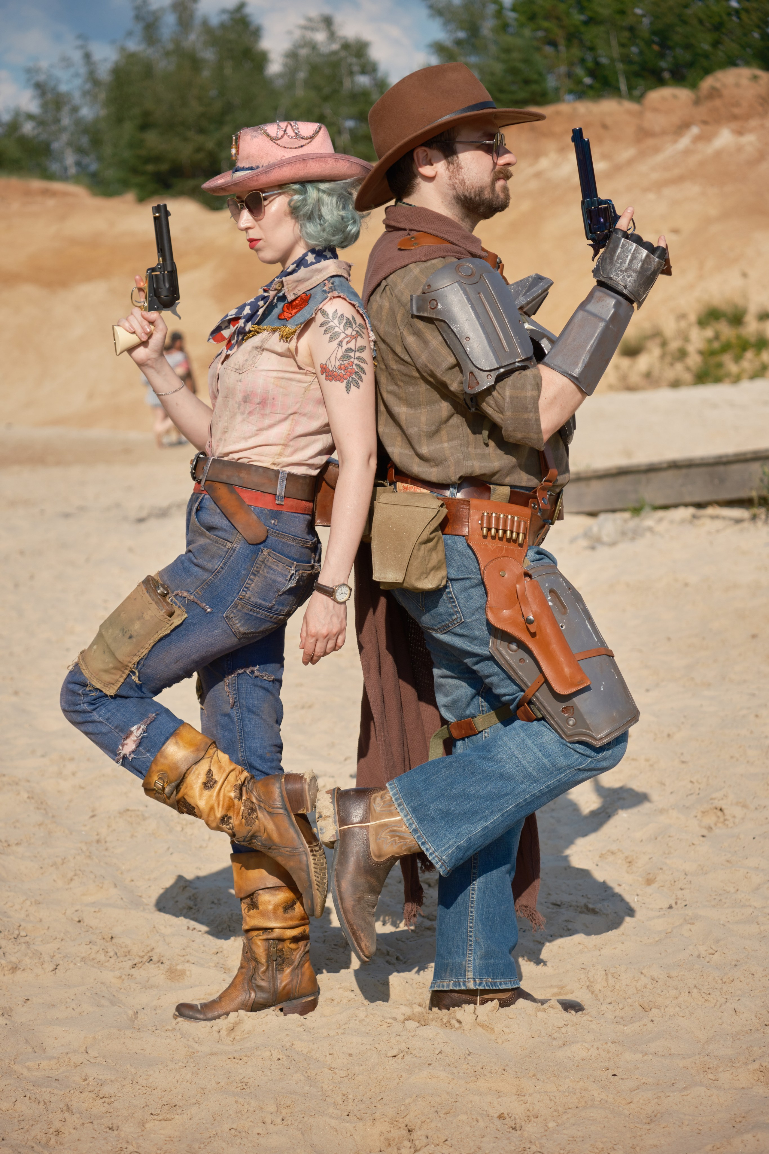 Мужчина и девушка в ковбойских шляпах и револьверами стоят спина к спине в стиле пост апокалипсис