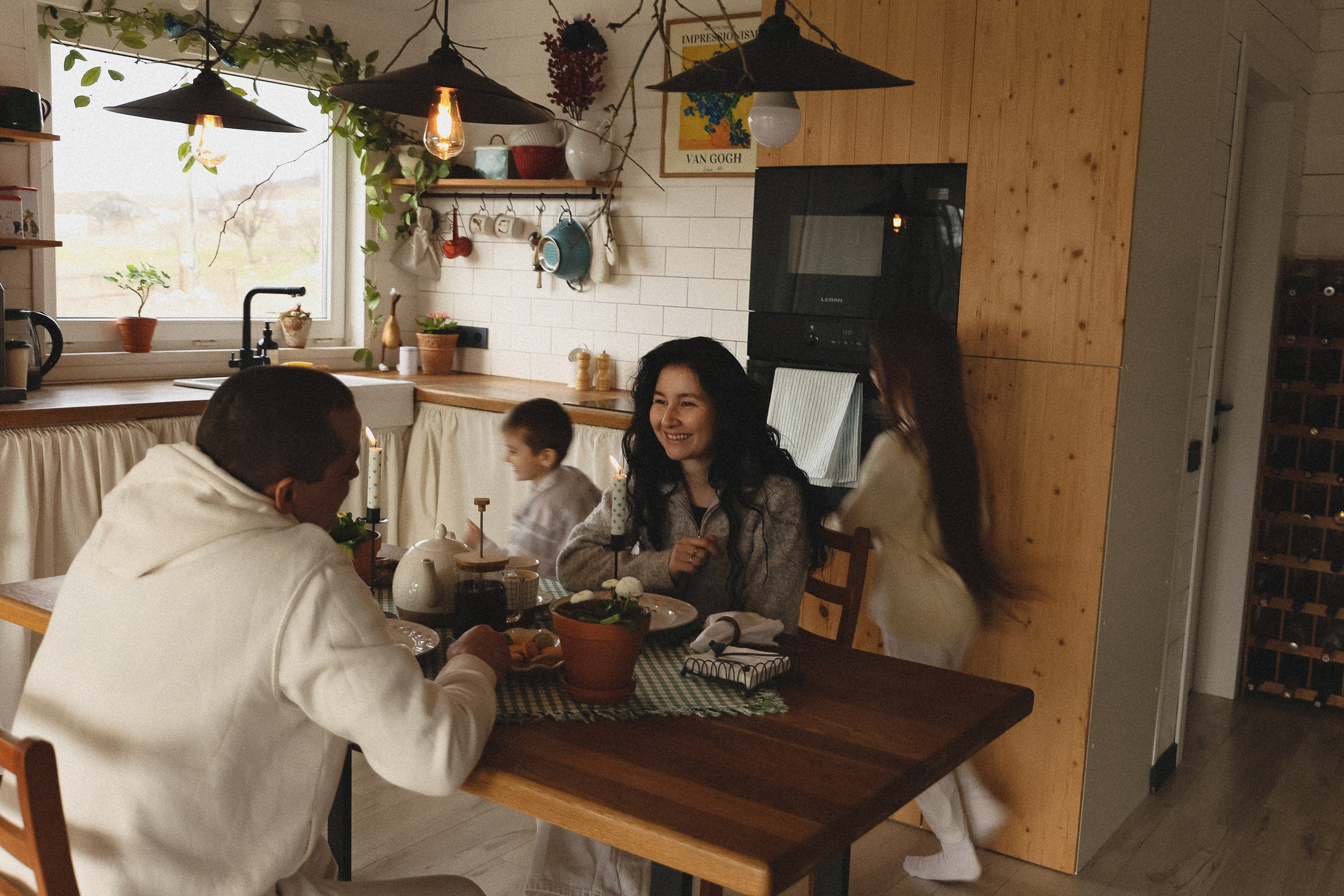 Дети бегают вокруг стола за которым сидят родители