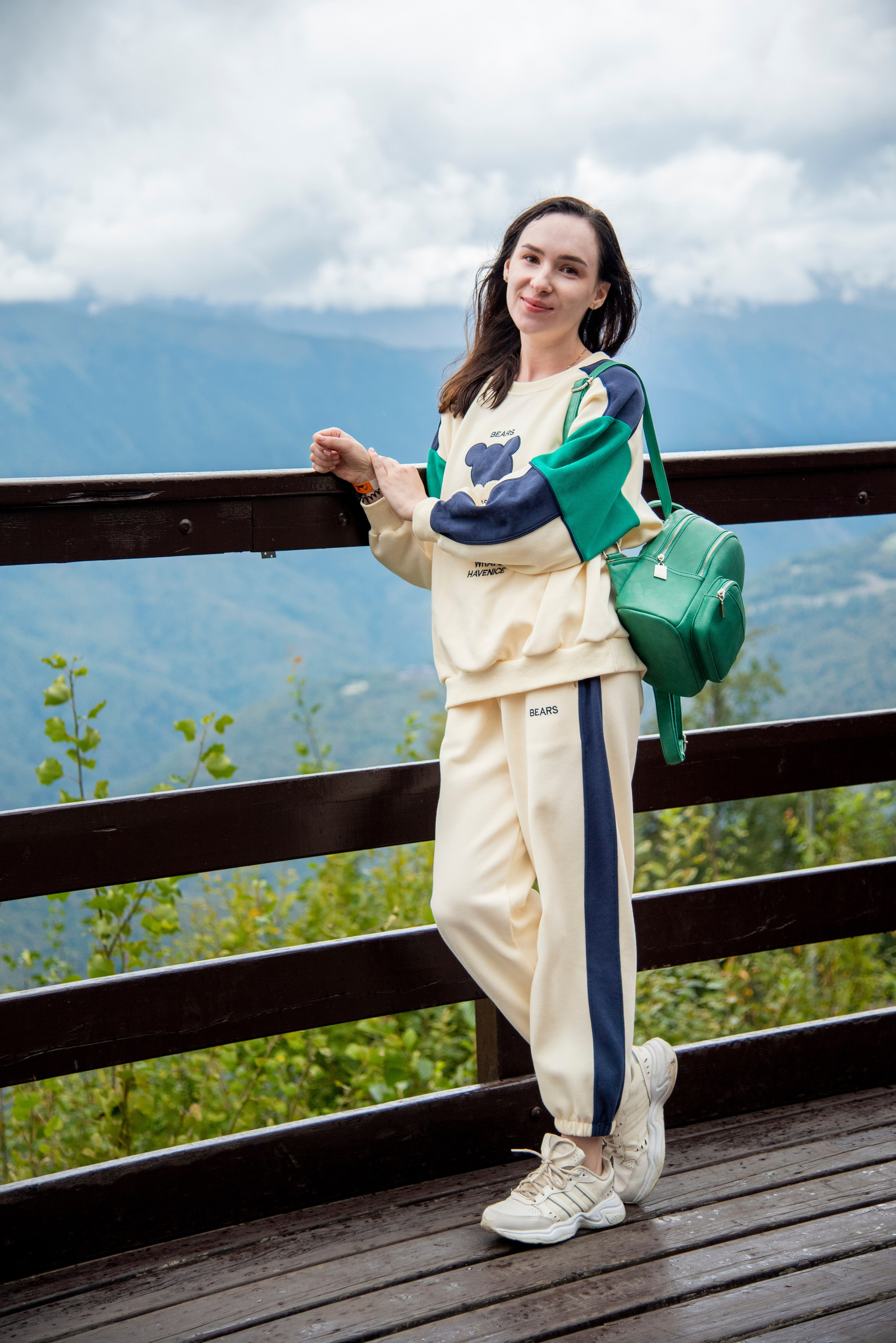 Брюнетка, на фоне гор. Красная поляна, спортивный костюм, рюкзачёк