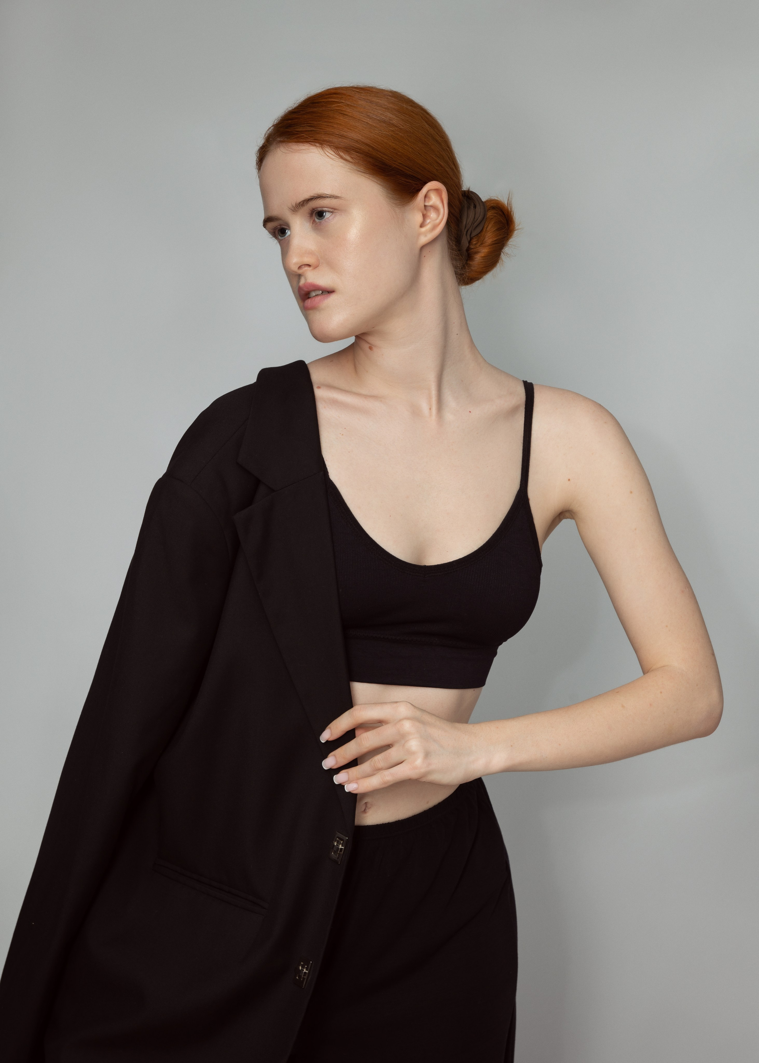 Портрет рыжеволосой девушки-модели в черном пиджаке на сером фоне. Модельные тесты