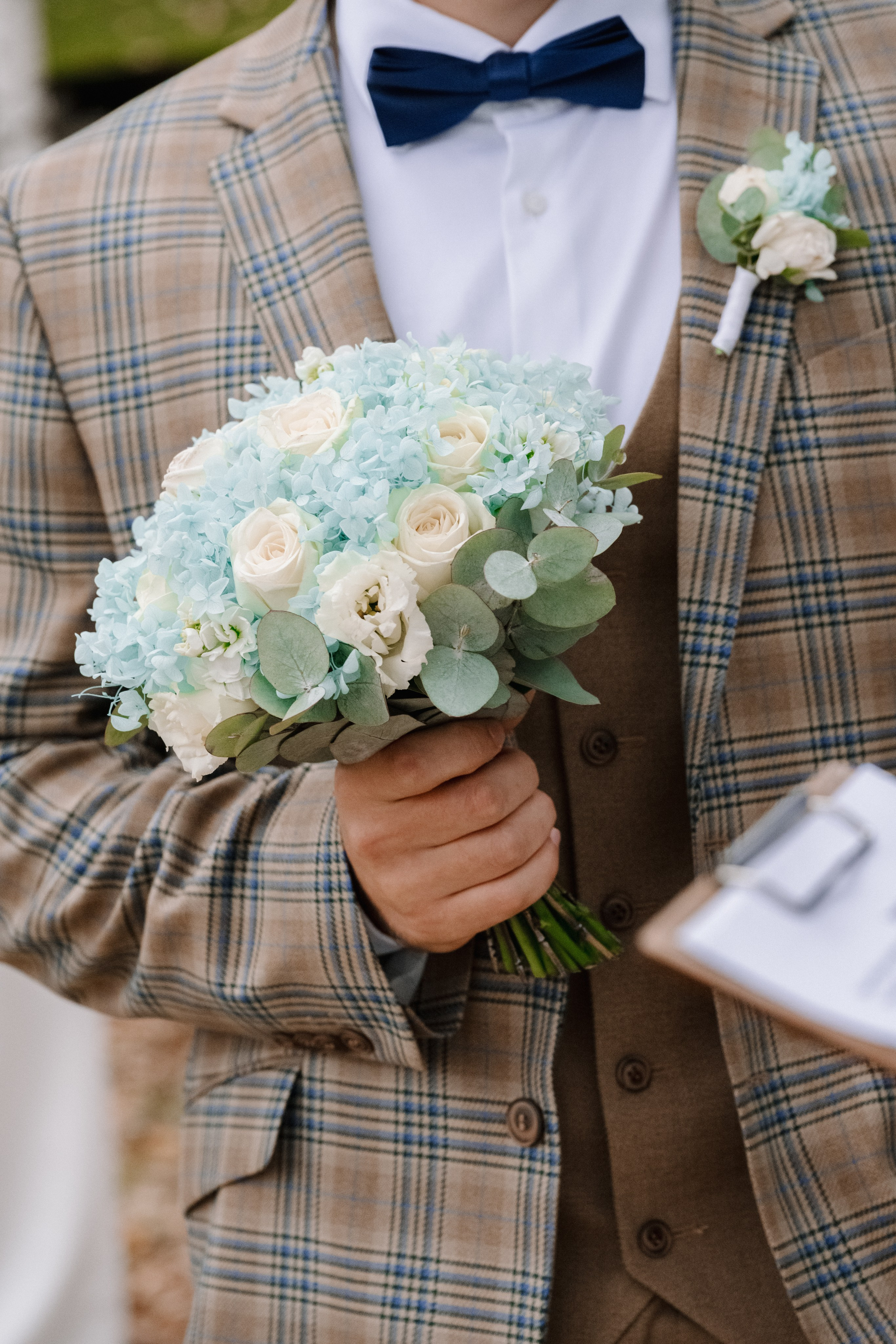 Нежный букет невесты, который держит жених в своих руках