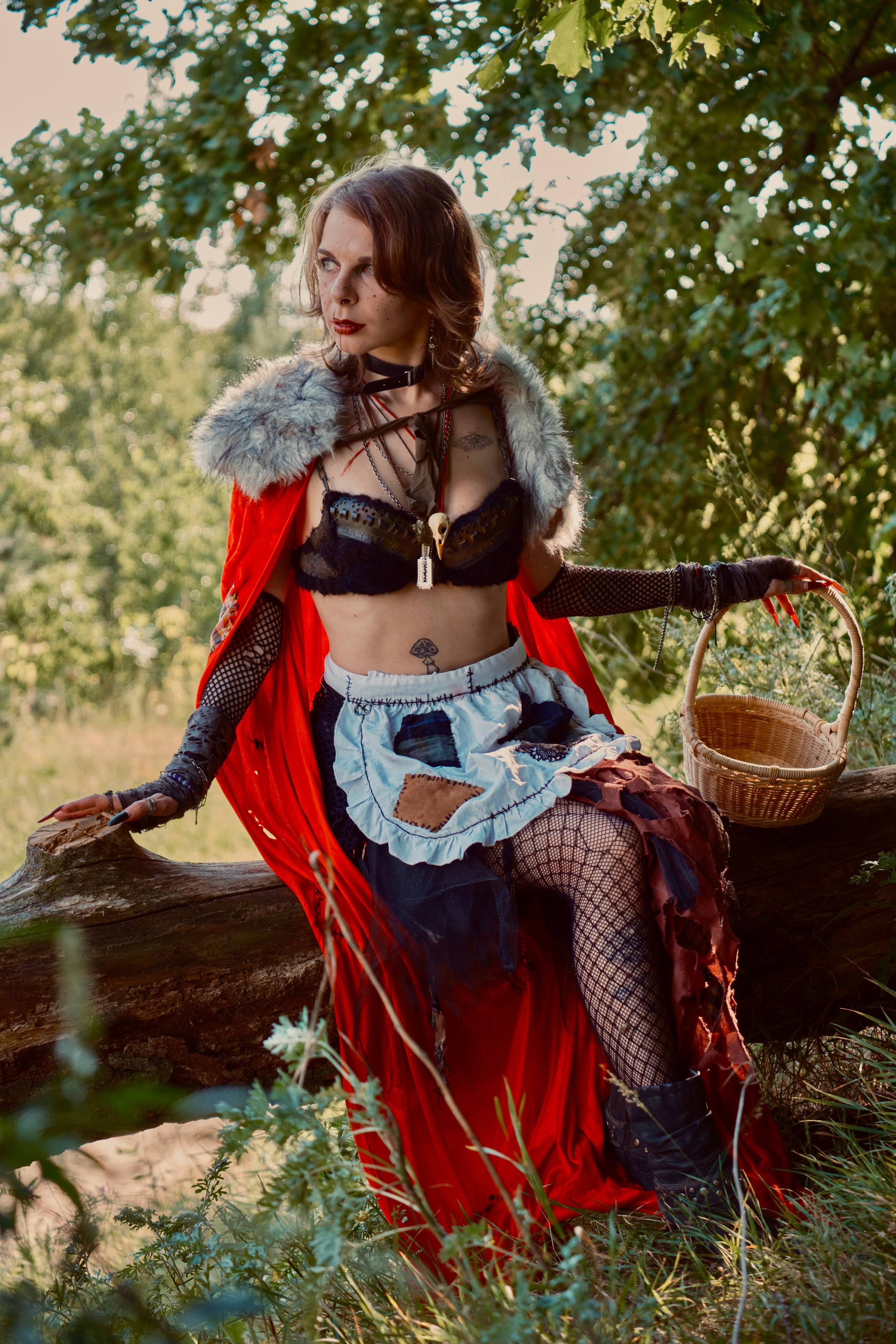 Девушка в красном плаще с корзиночкой гуляет в лесу